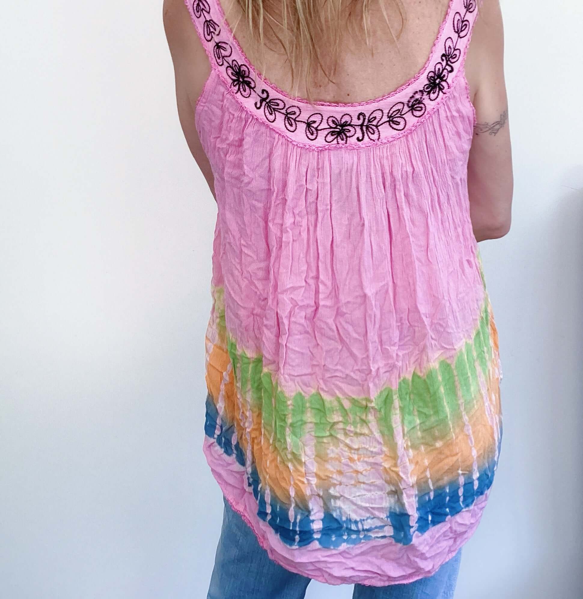 Back view of tie-dyed pink top, embroidered edges, with blue, orange, green bands at the bottom.