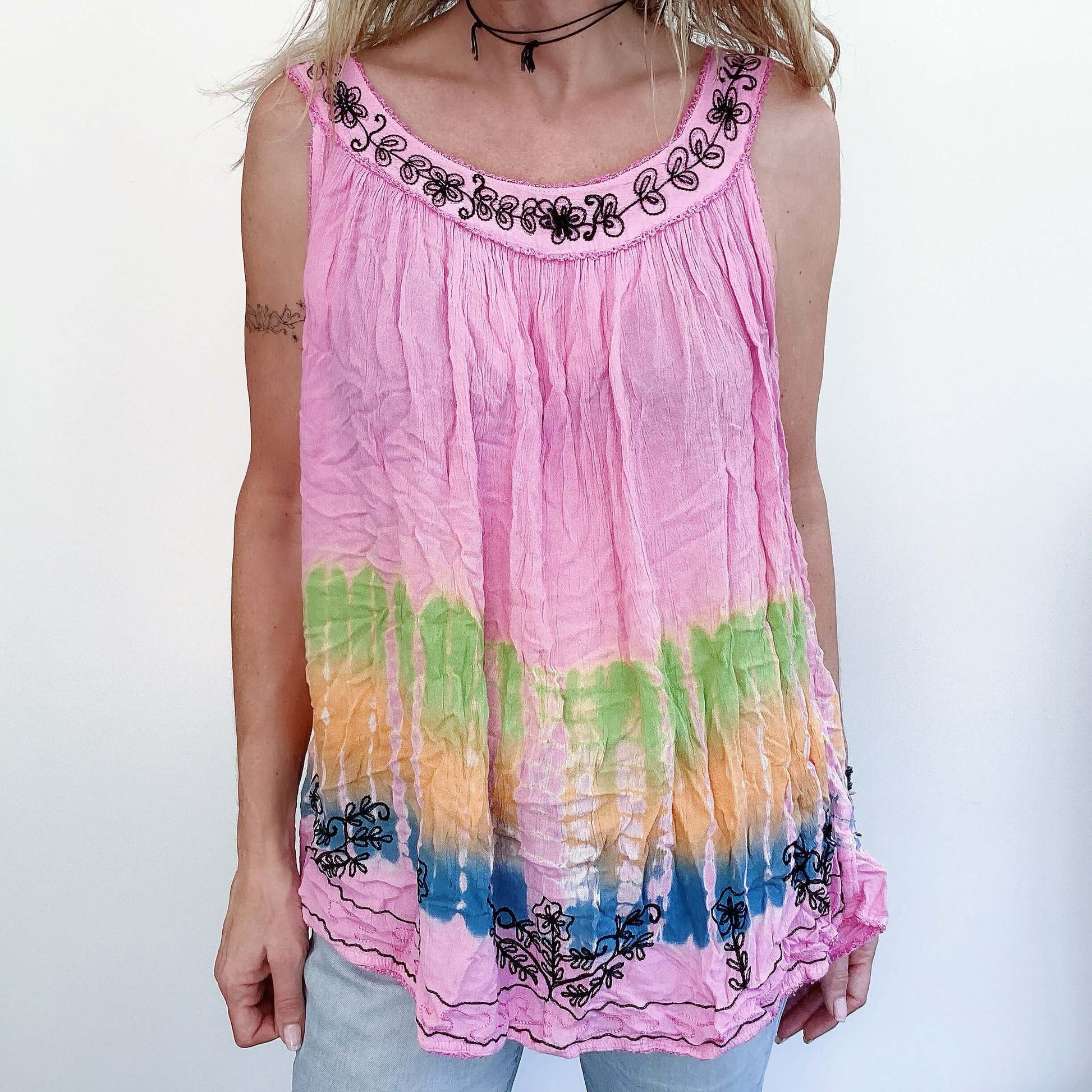 Front view of tie-dyed pink top, embroidered edges, with blue, orange, green bands at the bottom, length to upper thigh.