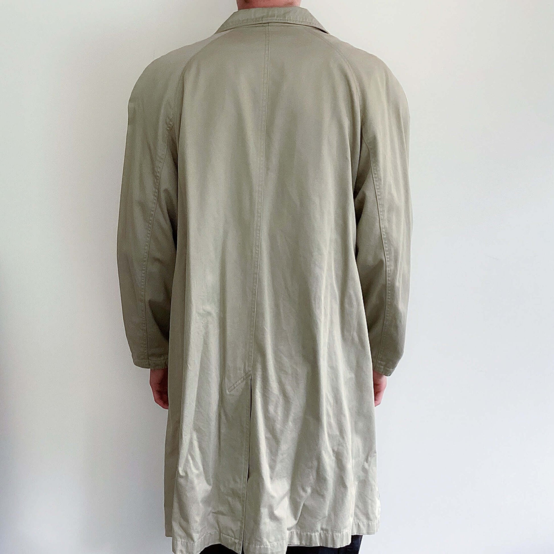 Beige double-breasted knee length jacket, back view.