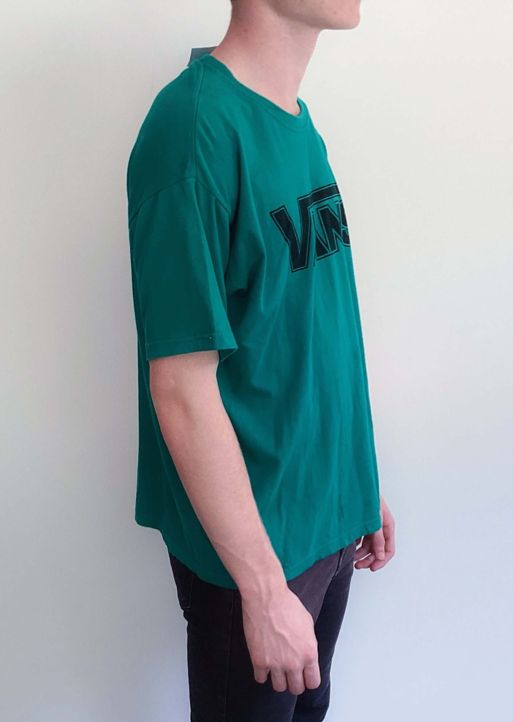 Side and right view of teal green tshirt, with vans logo printed on the chest in black.