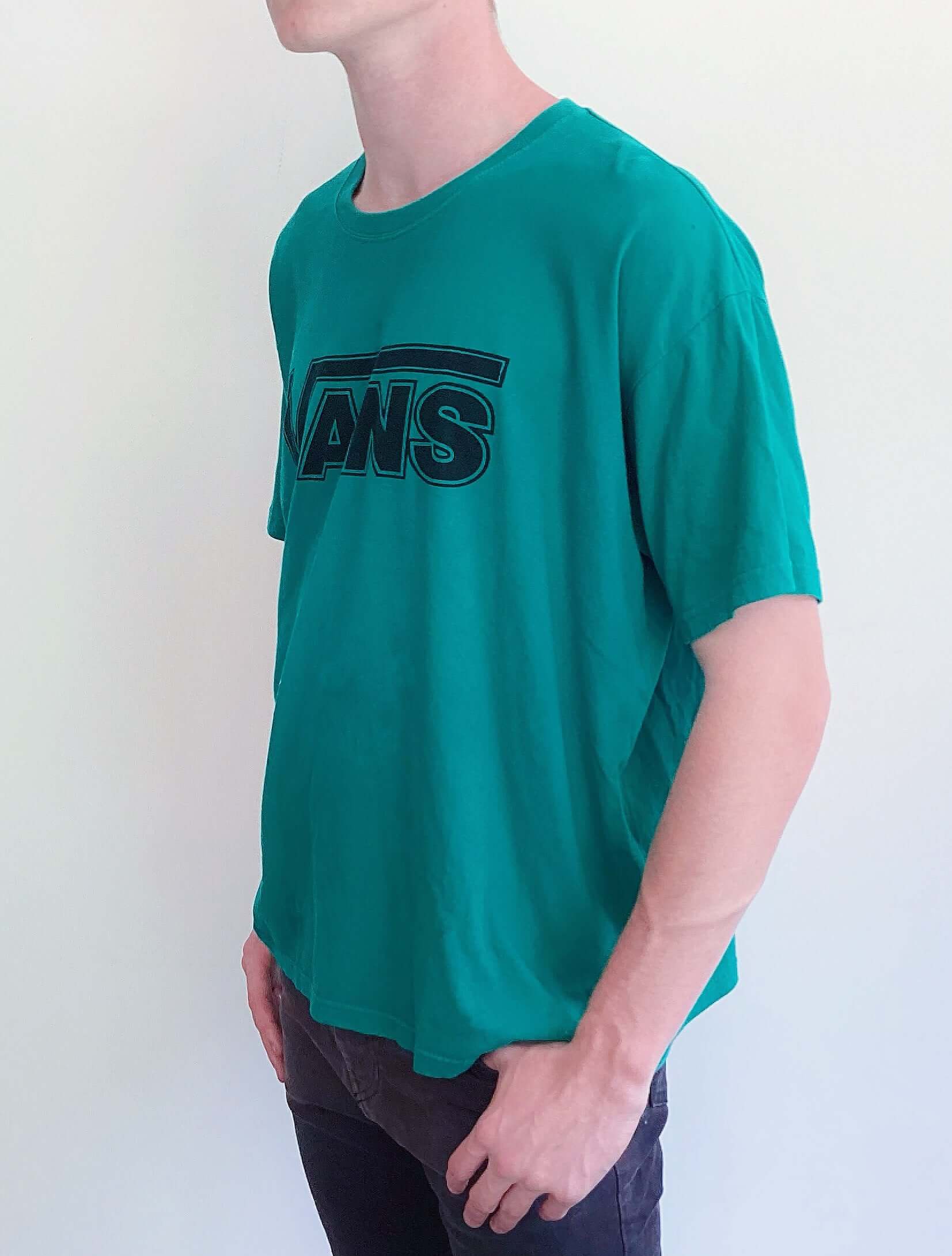 Side and left view of teal green tshirt, with vans logo printed on the chest in black.