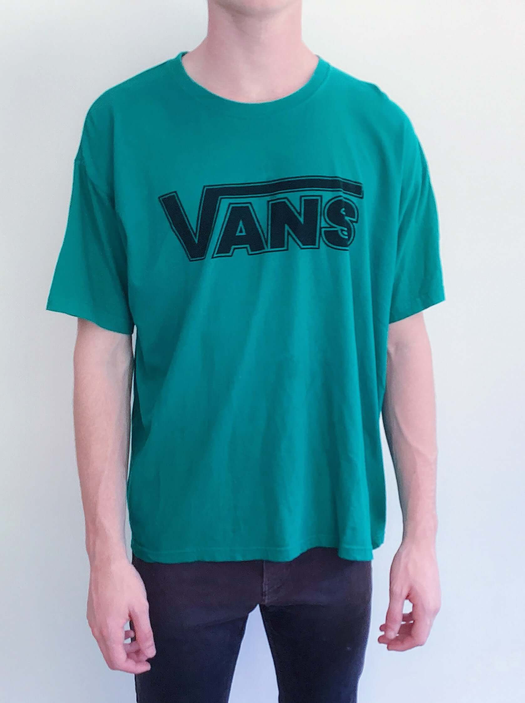 Front view of teal green tshirt, with vans logo printed on the chest in black.