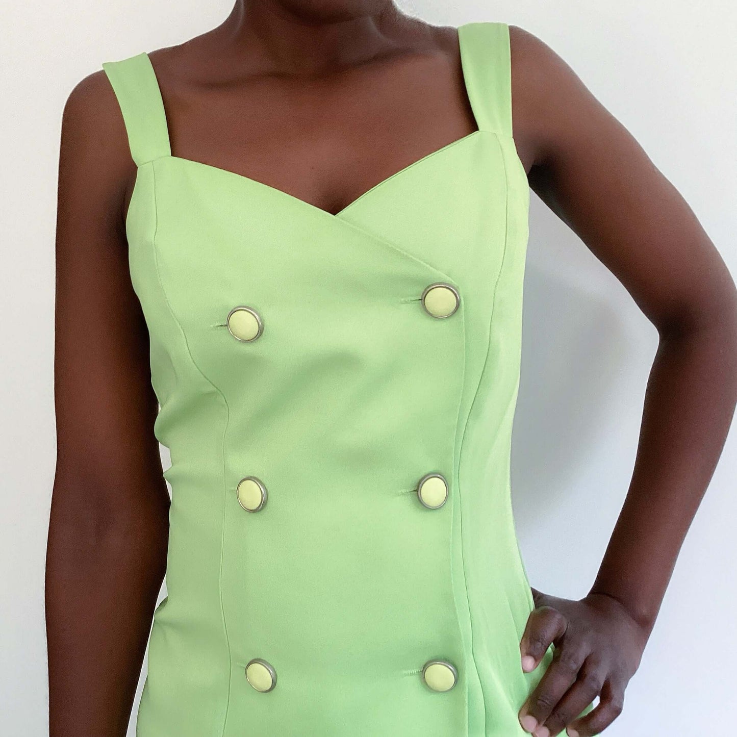 Detail view of avo mint double breasted cami top, off white buttons, upper thigh length.