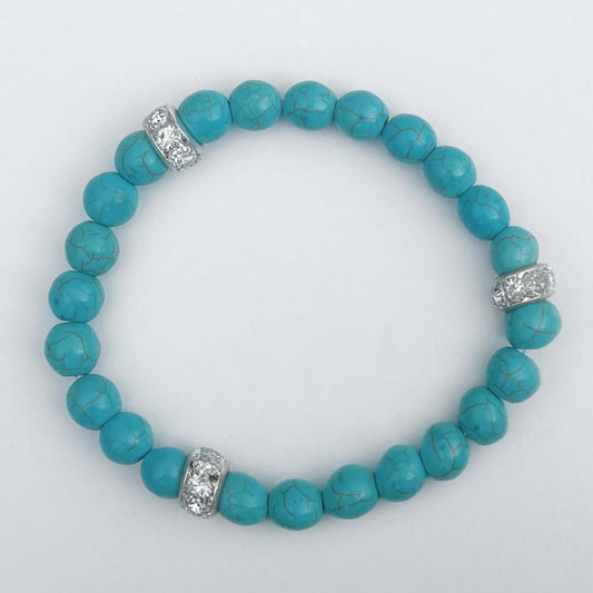 Top view of elasticated bracelet, showing the turquoise beads with pale black striations.