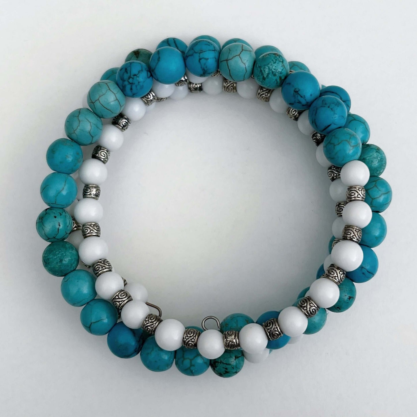 Top view of bracelet, mixture of Blue Howlite in sections, alternating with white glass and silver finish bead sections.