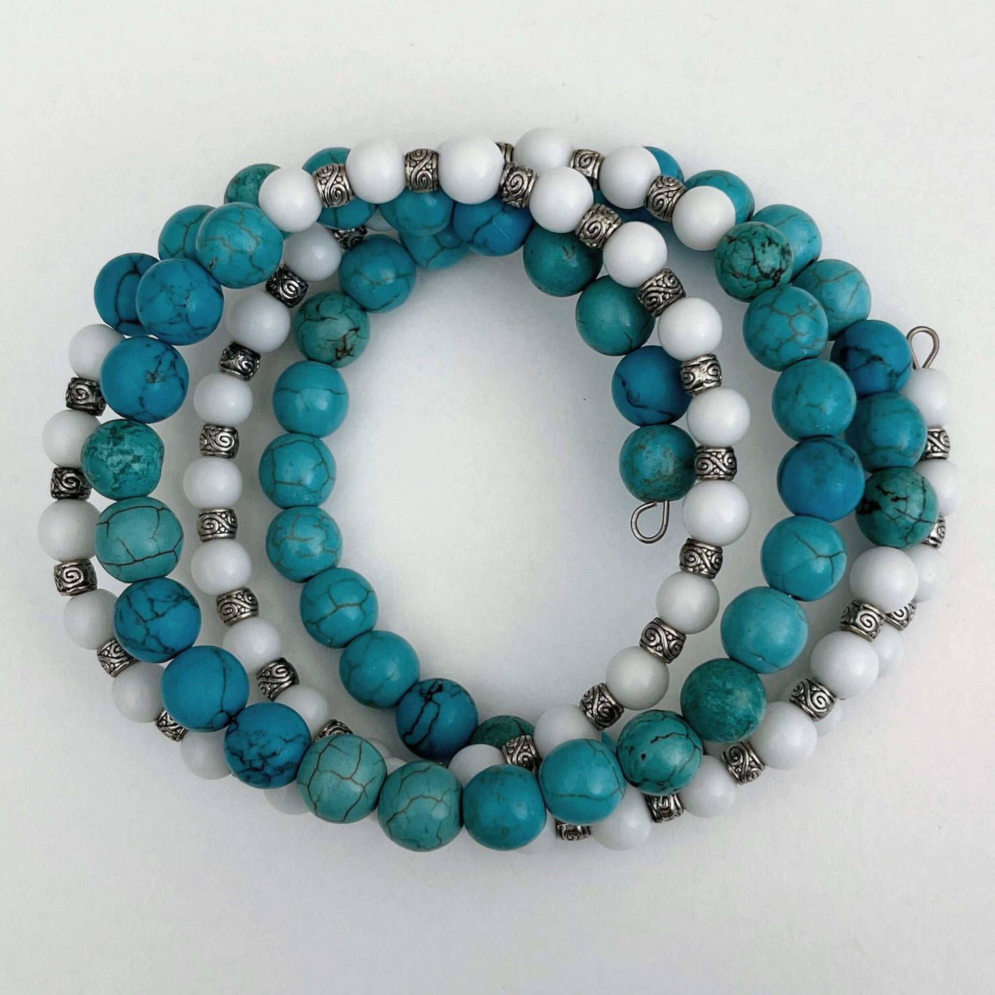 Top view of bracelet, mixture of Blue Howlite in sections, alternating with white glass and silver finish bead sections.