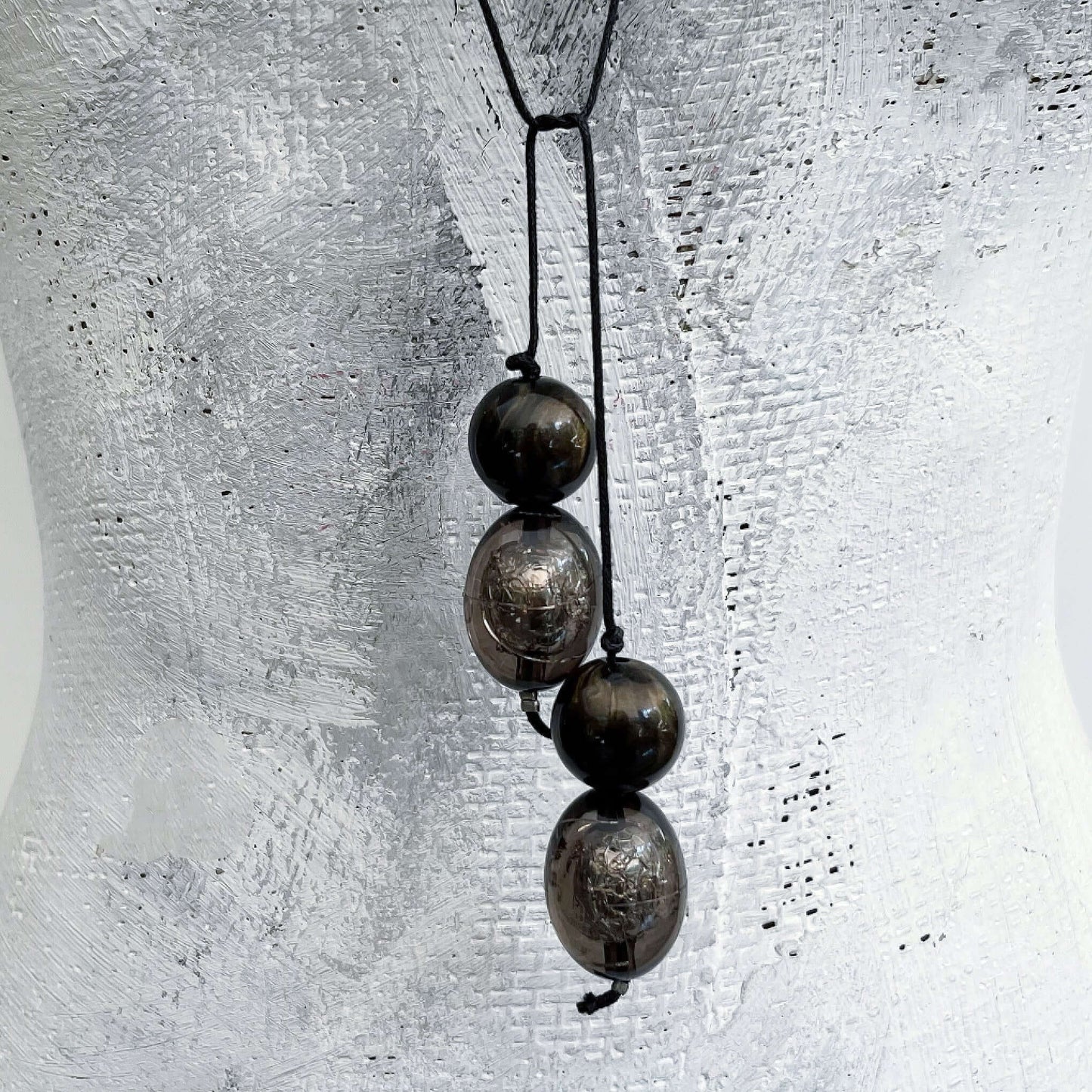 Detail view of necklace showing the ends lightly tied and dangling with beads in the front.