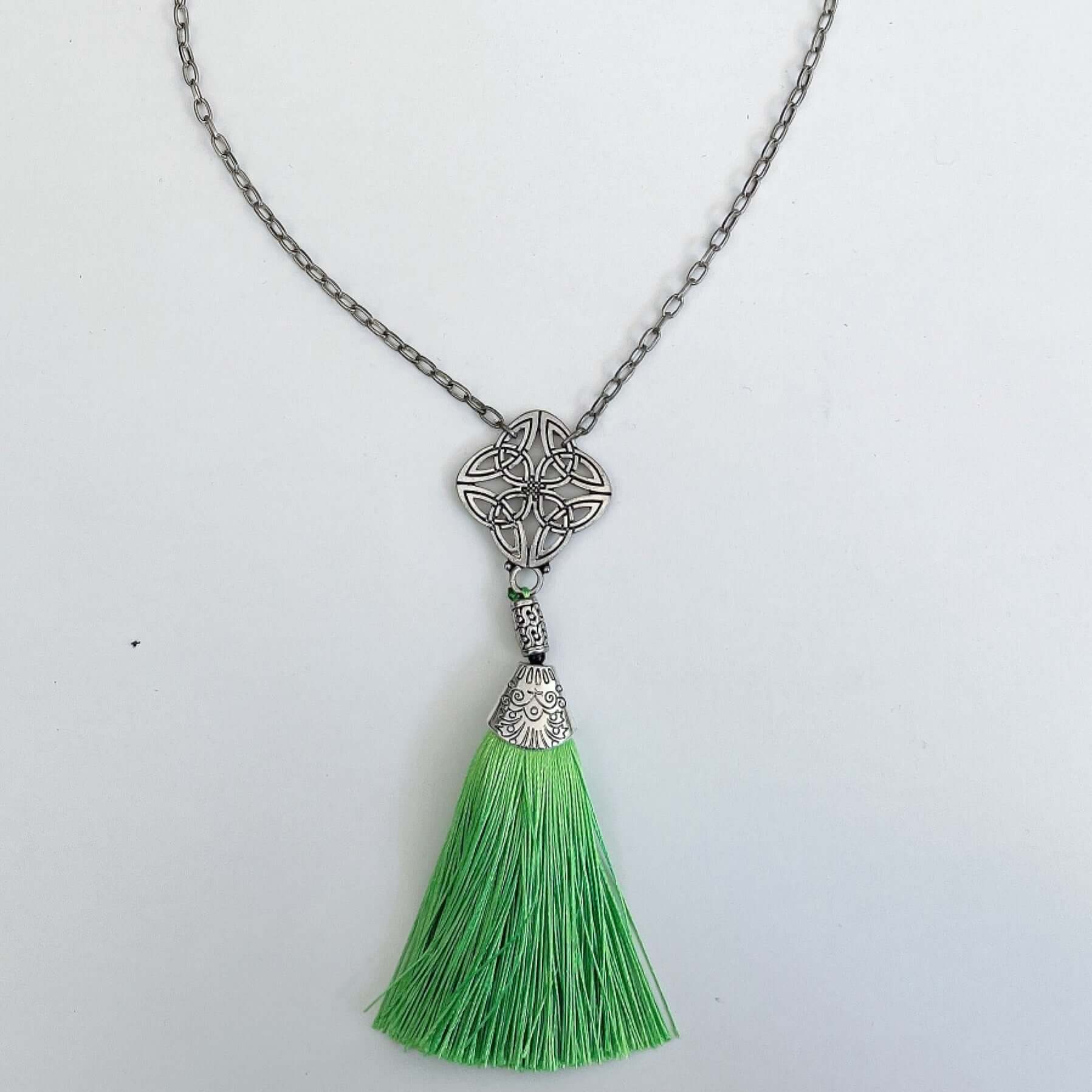 Top view of the silver finish Celtic pendant, with green tassel on the end.