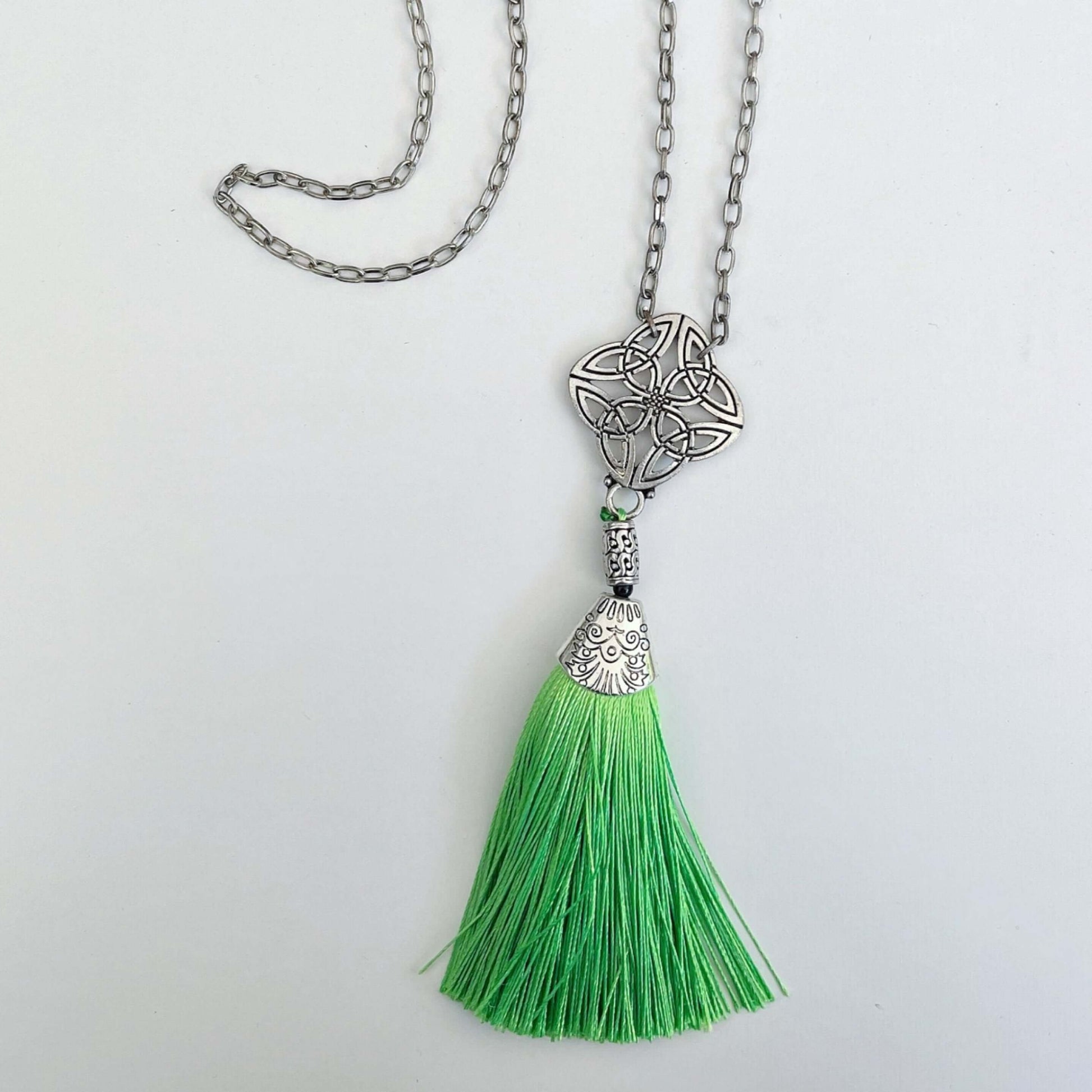 Top view of the silver finish Celtic pendant, with green tassel on the end.