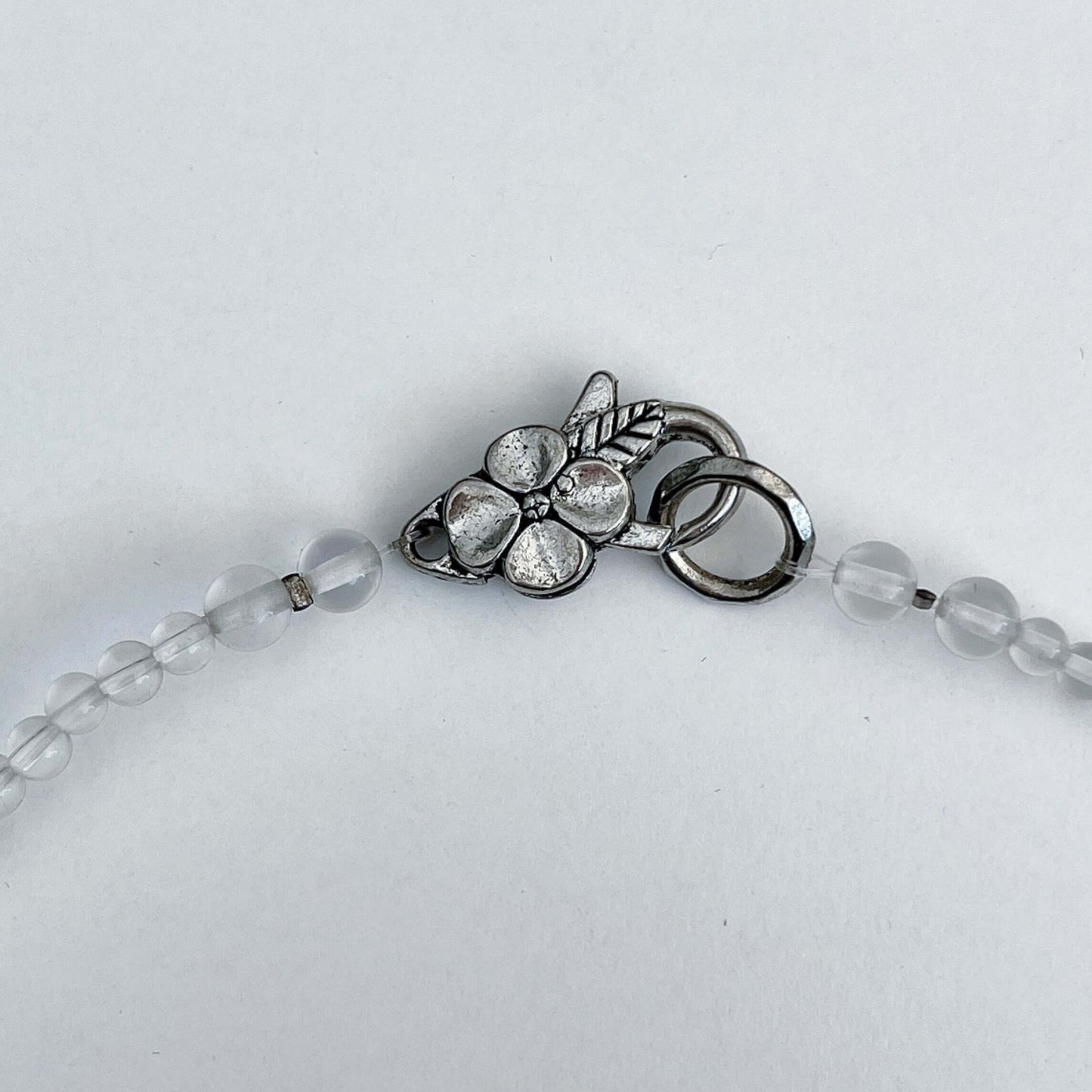 Detail view of the silver finish floral clasp.