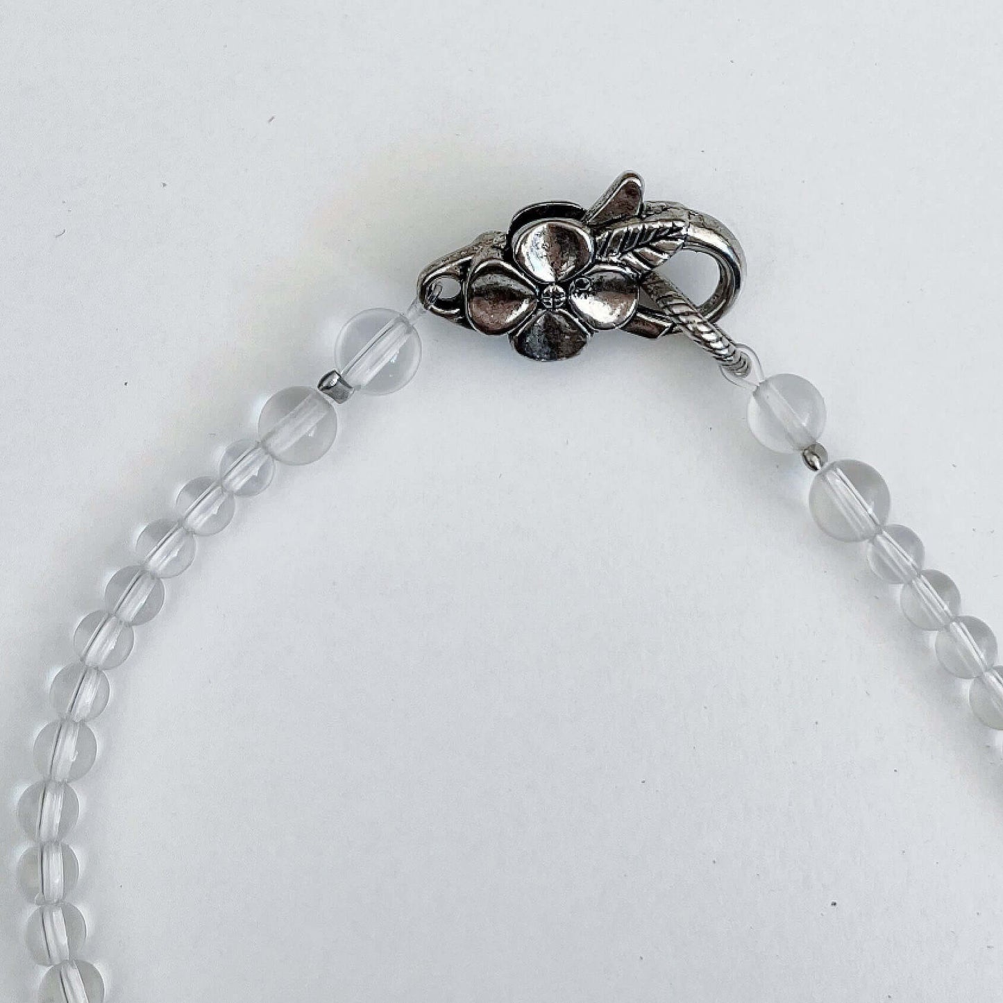 Detail view of the silver finish floral clasp, with Clear Quartz beading at each side.