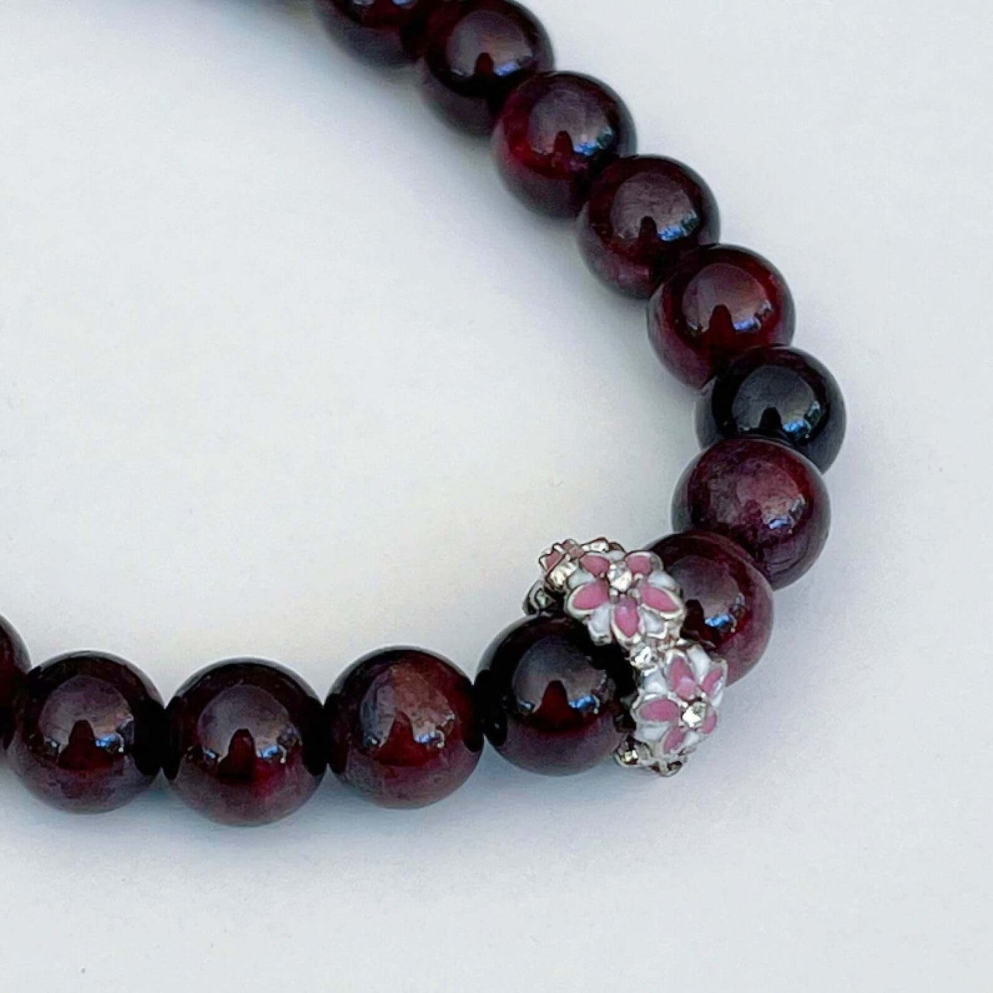 Detail view of elasticated bracelet, showing the individual beads, which have a deep plum/black coloring