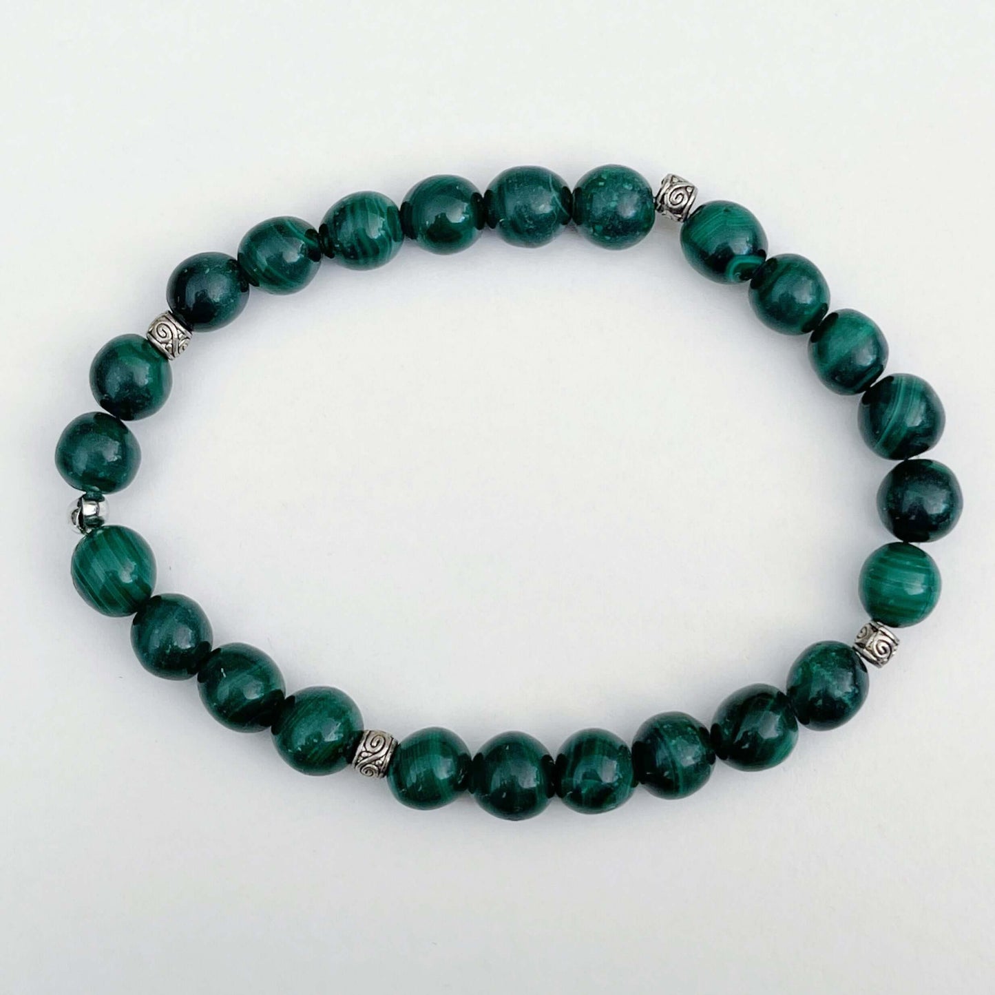 Top view of elasticated bracelet, showing the shades of deep green beads.