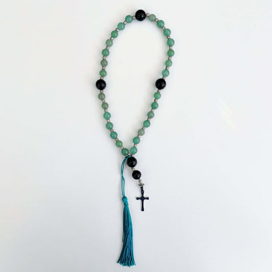 Top view of prayer beads, Aventurine sections, with one Obsidian here and there. Cross and tassel at the bottom.