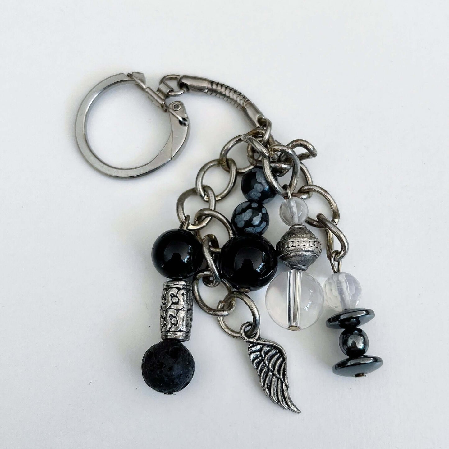 Top view of keyring showing 5 dangling chains each with beads, and one with the angel wing charm.