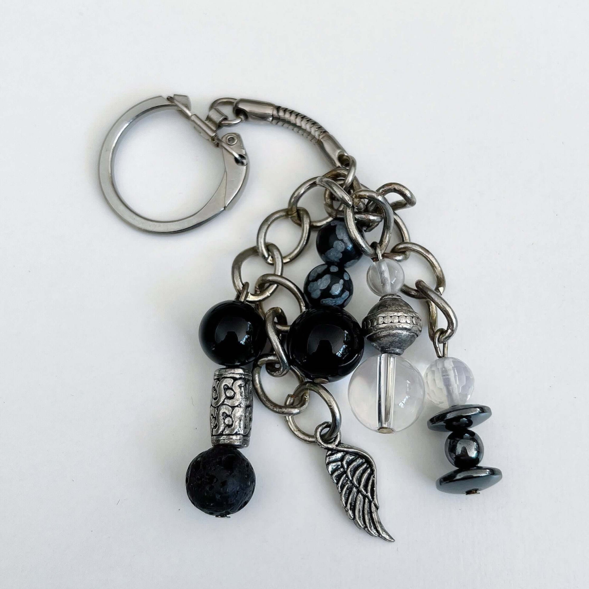 Top view of keyring showing 5 dangling chains each with beads, and one with the angel wing charm.