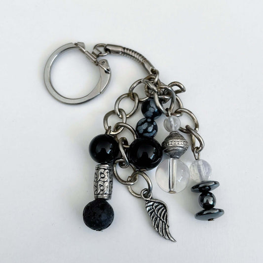 Top view of keyring showing 5 dangling chains each with beads, and one with the angel wing charm.
