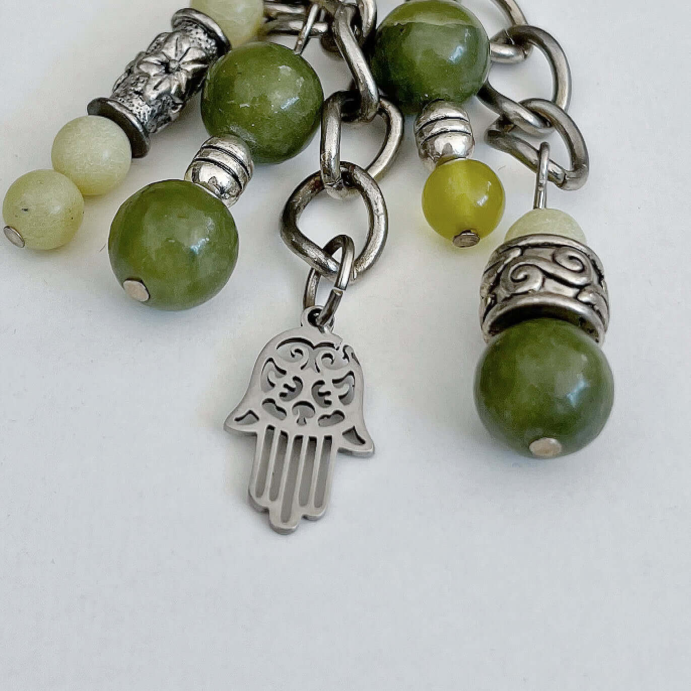 Detail view of keyring showing 5 dangling chains each with beads, and one with the Hamsa charm.