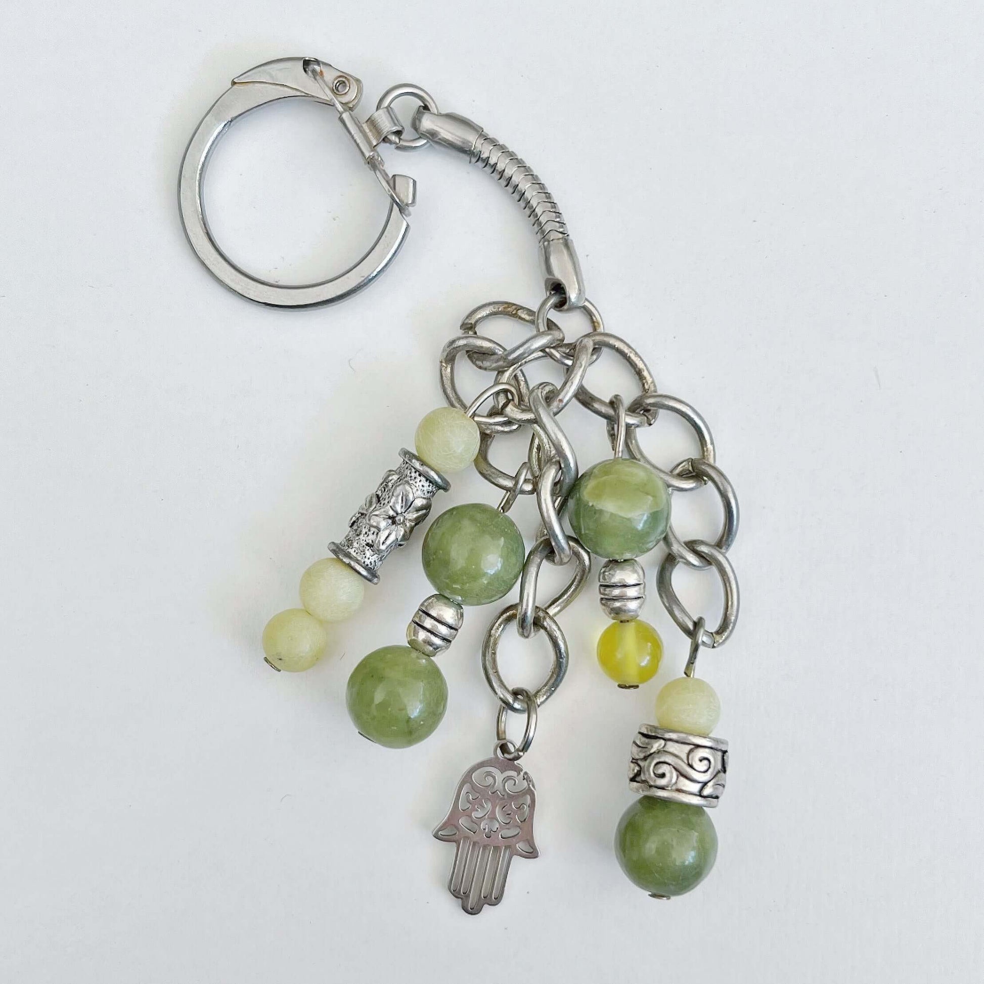 Top view of keyring showing 5 dangling chains each with beads, and one with the Hamsa charm.