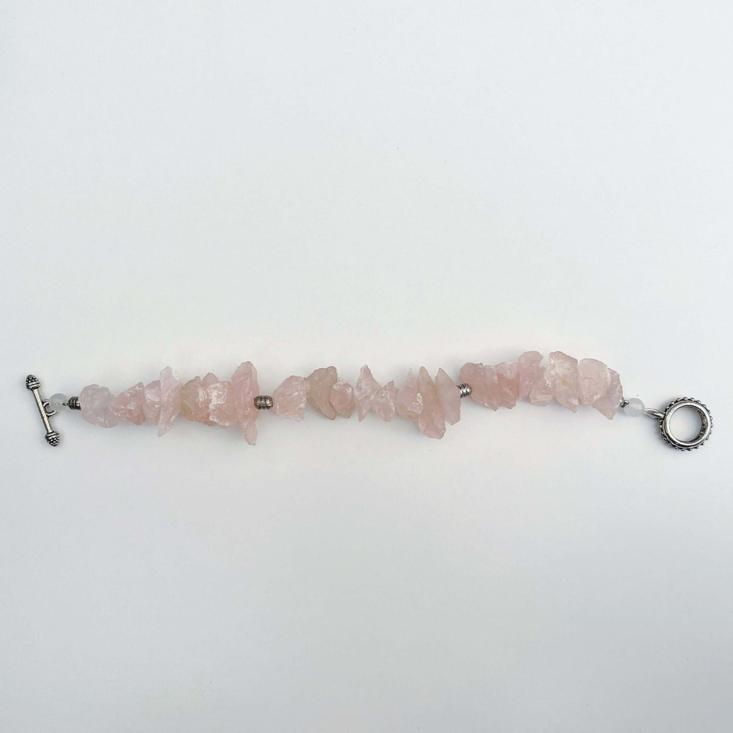 Top view of the rough Rose Quartz bracelet lying unclasped.