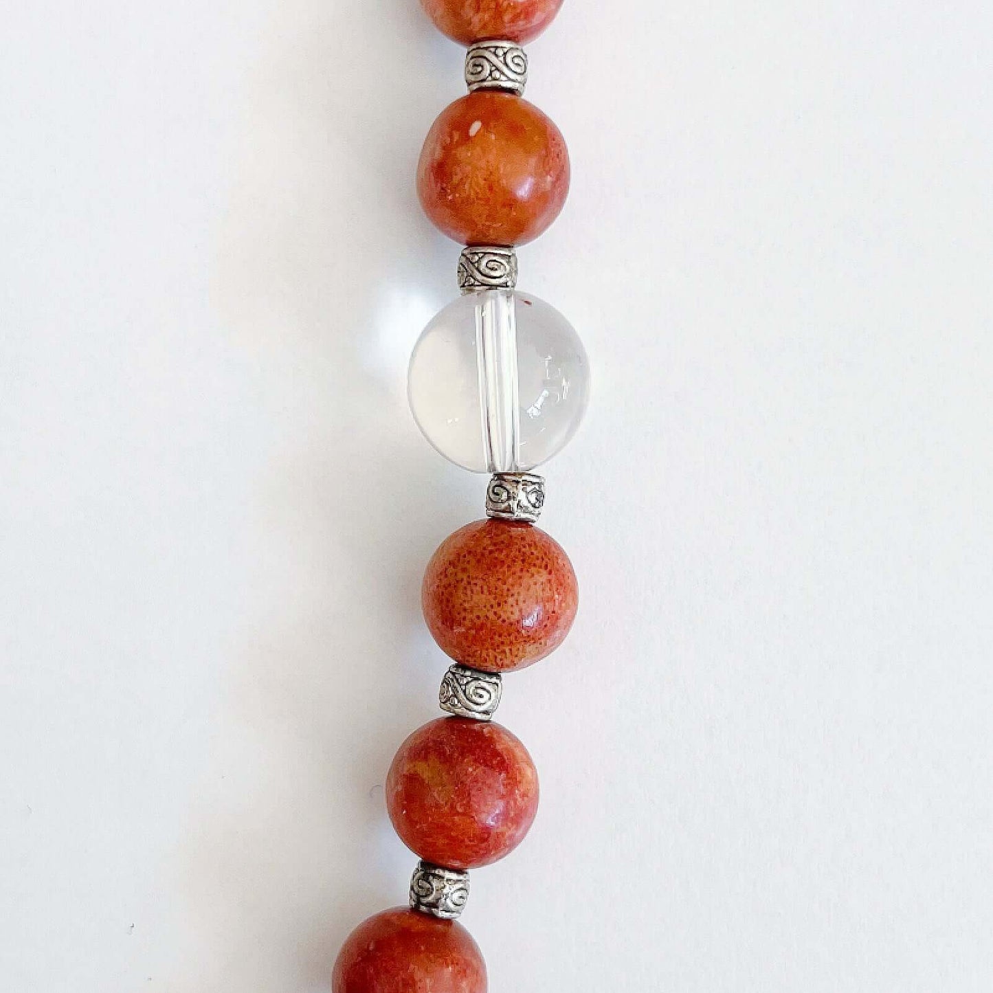 Detail view of the actual Coral and Clear Quartz beads, the latter is a slightly bigger size.