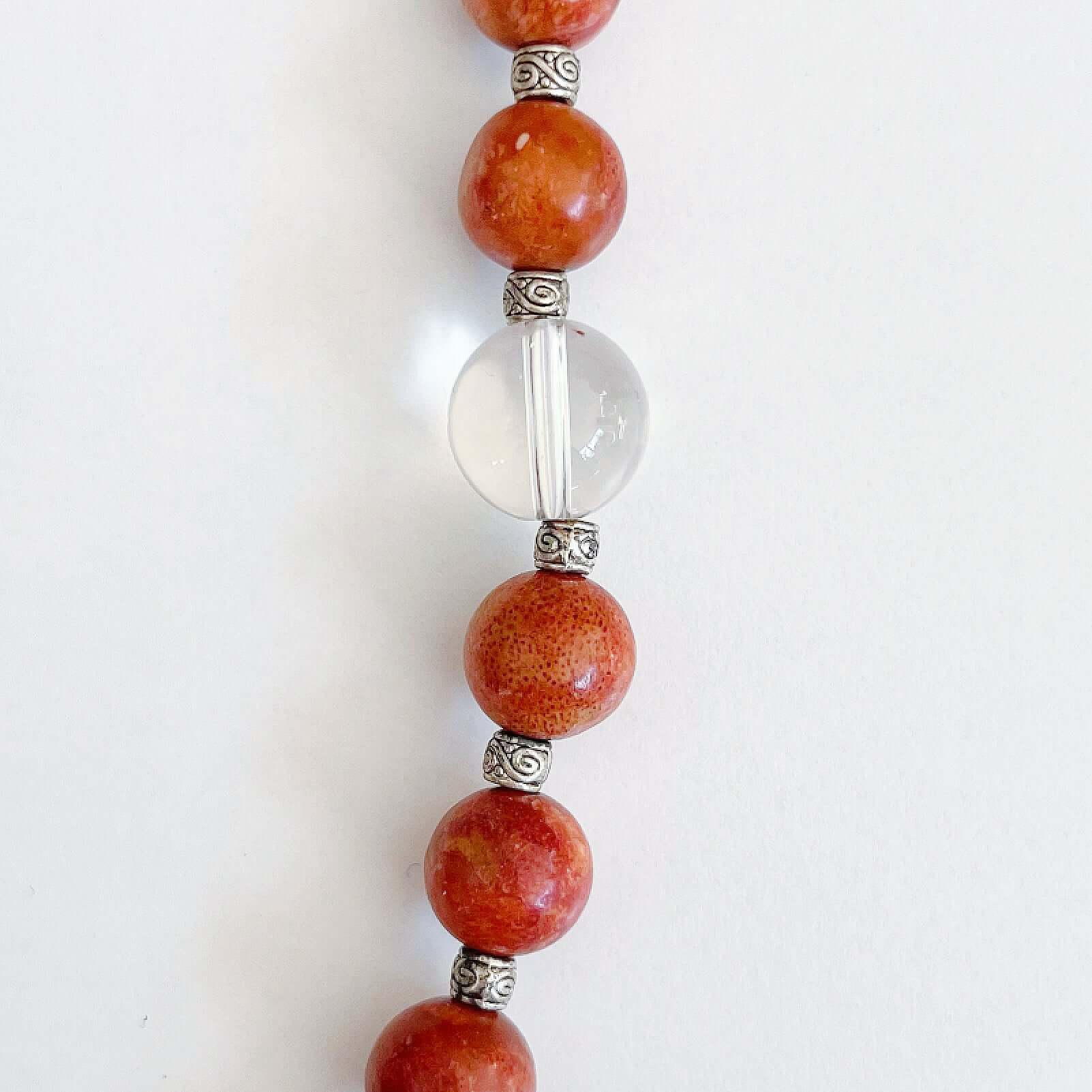 Detail view of the actual Coral and Clear Quartz beads, the latter is a slightly bigger size.