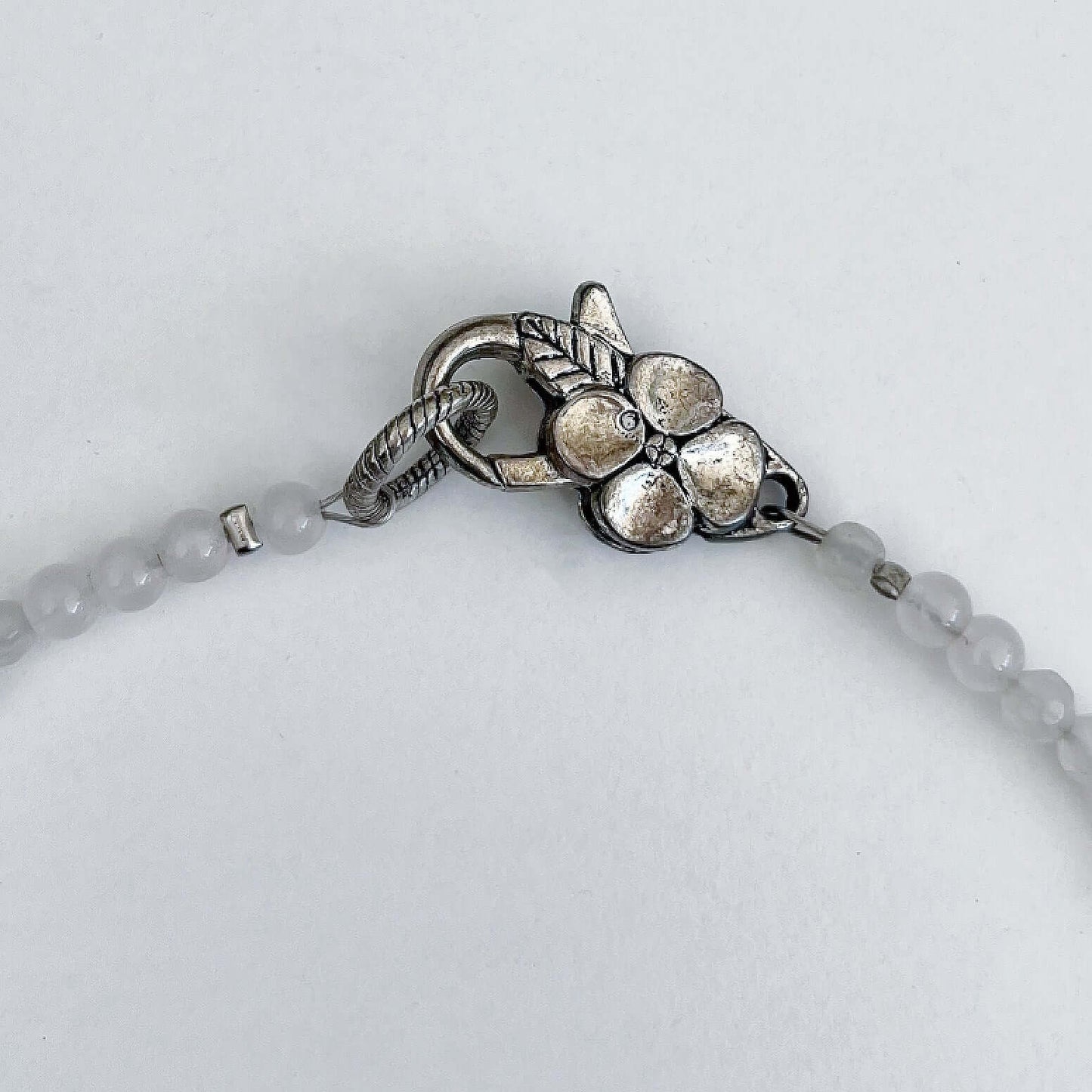 Detail view of the silver finish floral clasp, with Rose Quartz beading at each side.