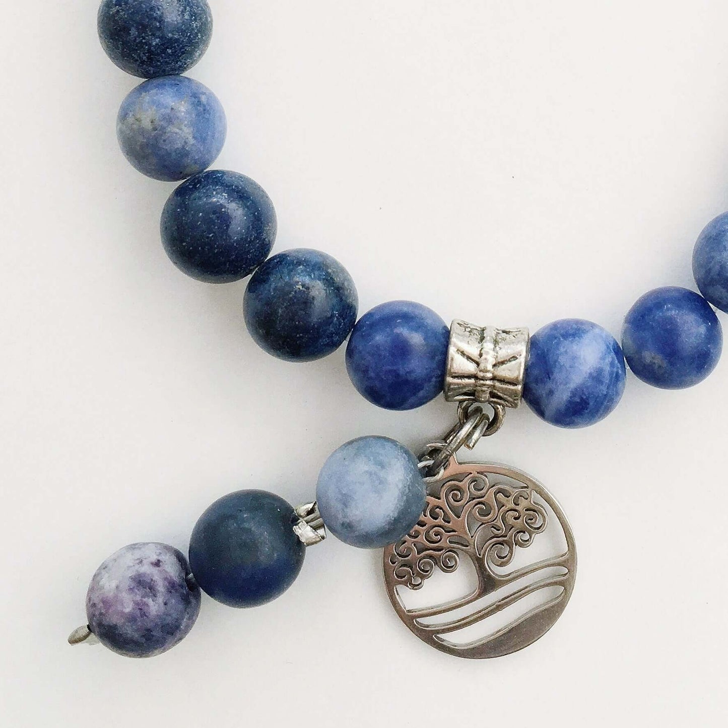 Detail view of beaded bracelet with matching 3 bead dangle and Tree Of Life attached to silver bead.