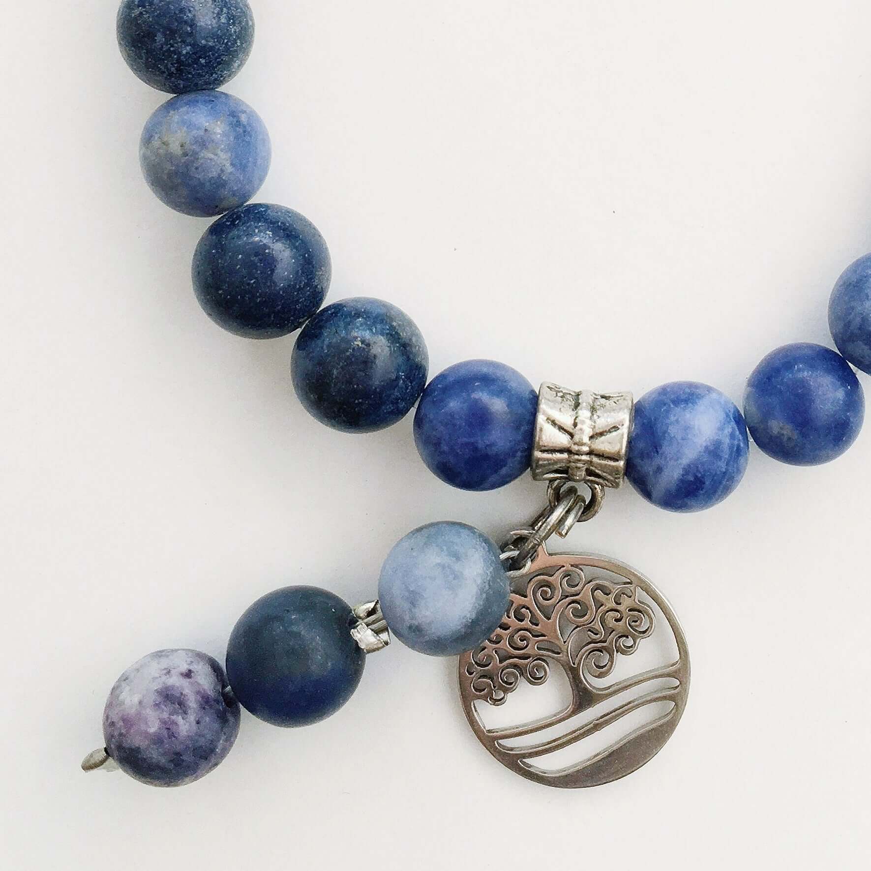 Detail view of beaded bracelet with matching 3 bead dangle and Tree Of Life attached to silver bead.