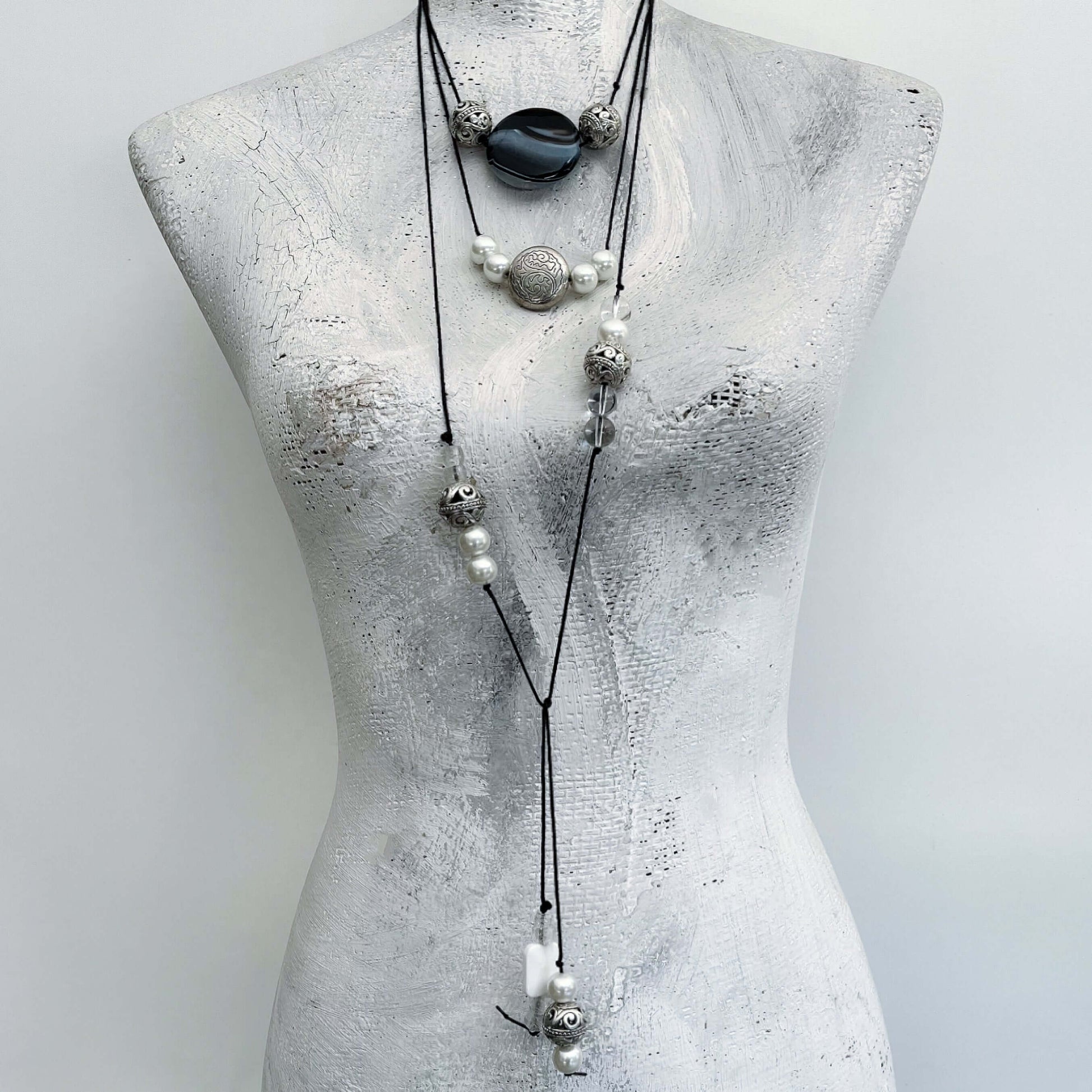 Front view of necklace shown wrapped around the neck in layers, beads in varying positions.