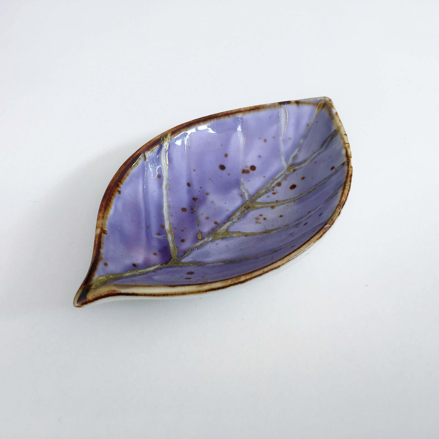 View of indigo painted ceramic leaf.