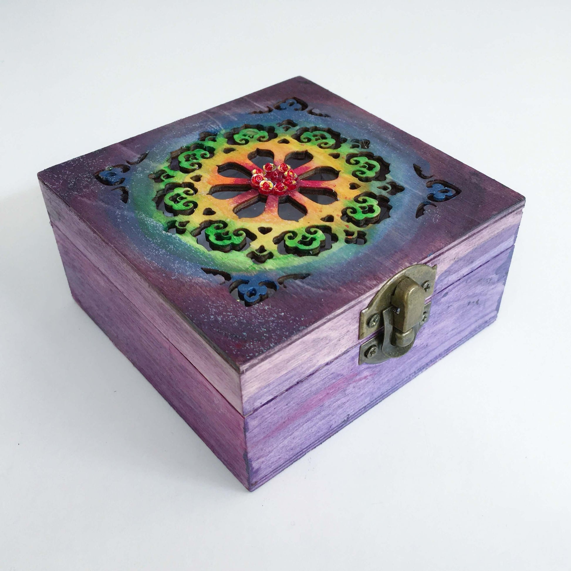 Outside view painted purple box, blending into rainbow shades on laser-cut lid, in ornate circular pattern, metal clasp.
