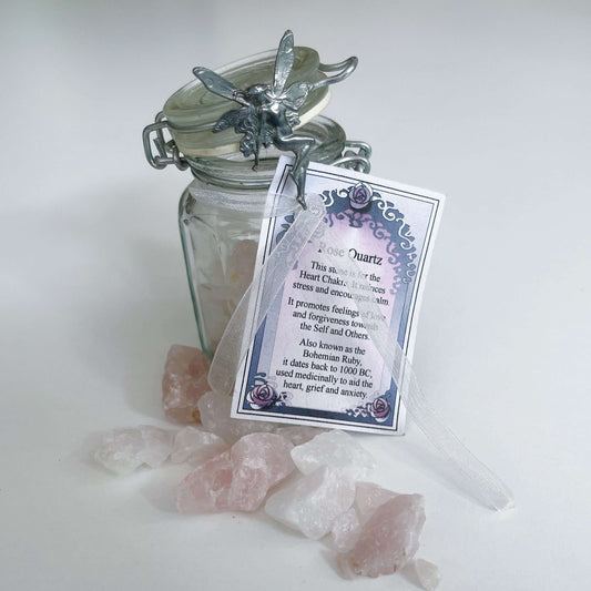 View of bottle with the lid open, ribbon tied around with inscription card, stones shown outside and inside.