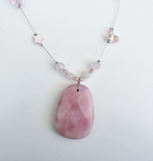 Detail view of Rose Quartz pendant, with gentle faceting on the surfaces.