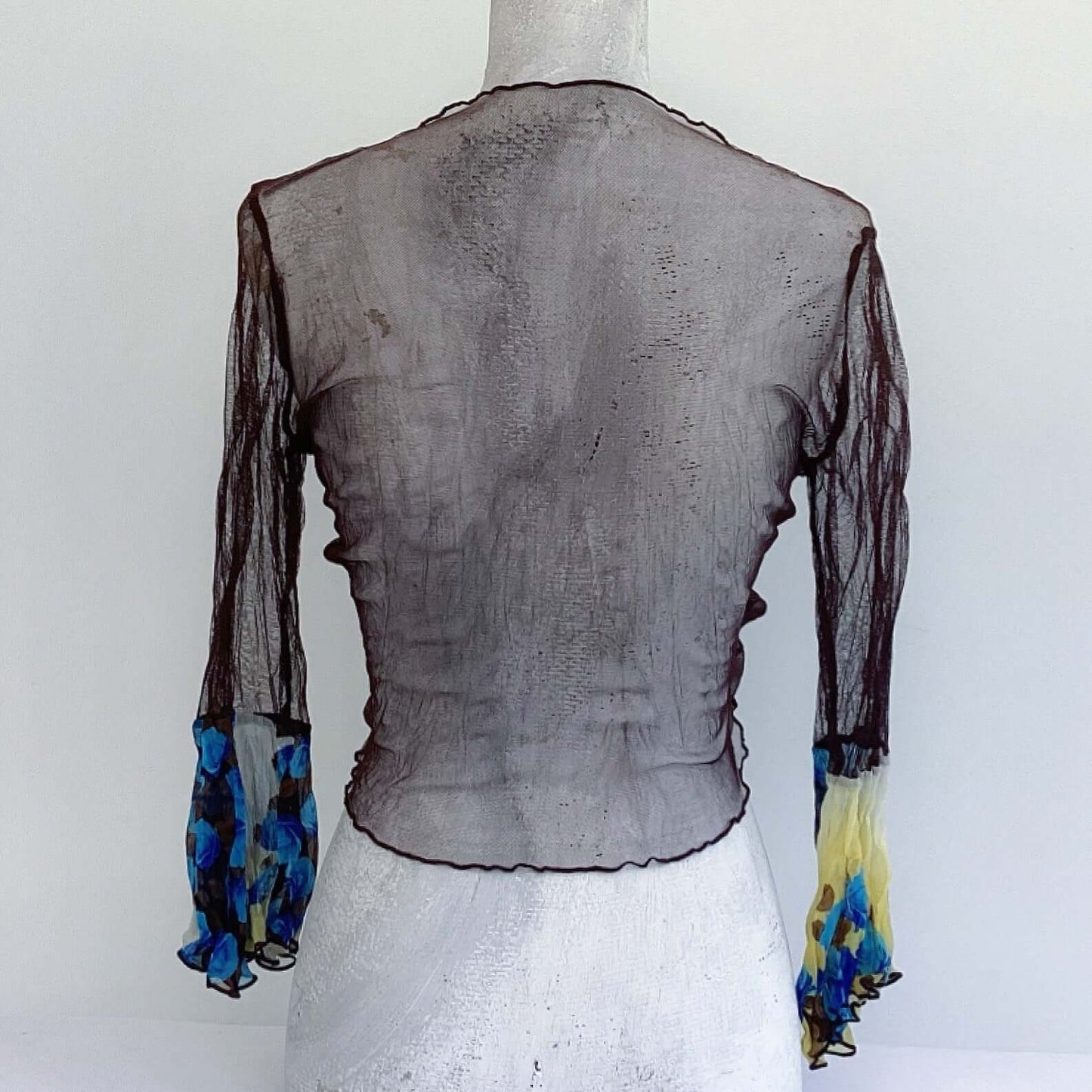 Back view of brown net tie top, with blue rose floral sleeves.