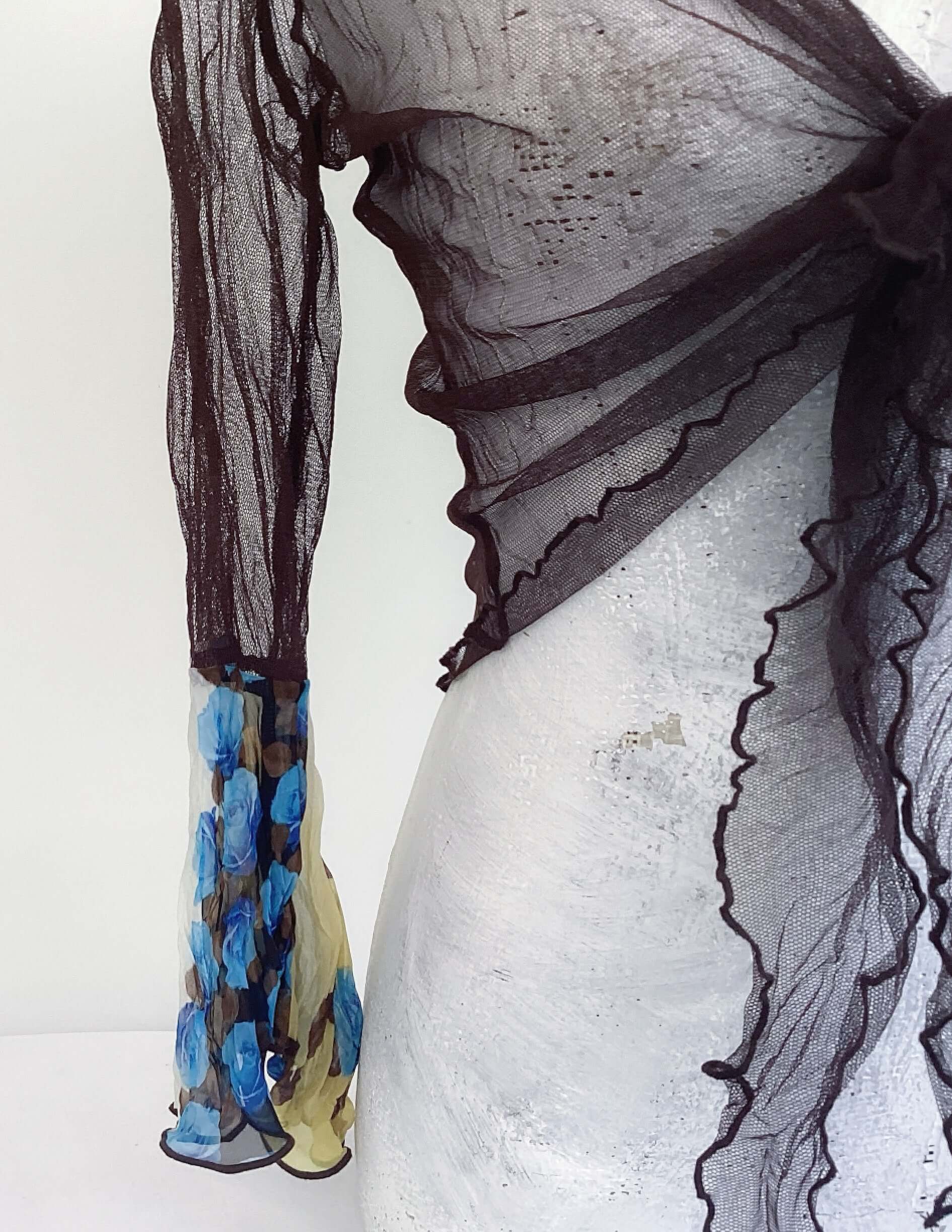 Close up view of brown net tie top, with chiffon blue and yellow rose floral left sleeve.