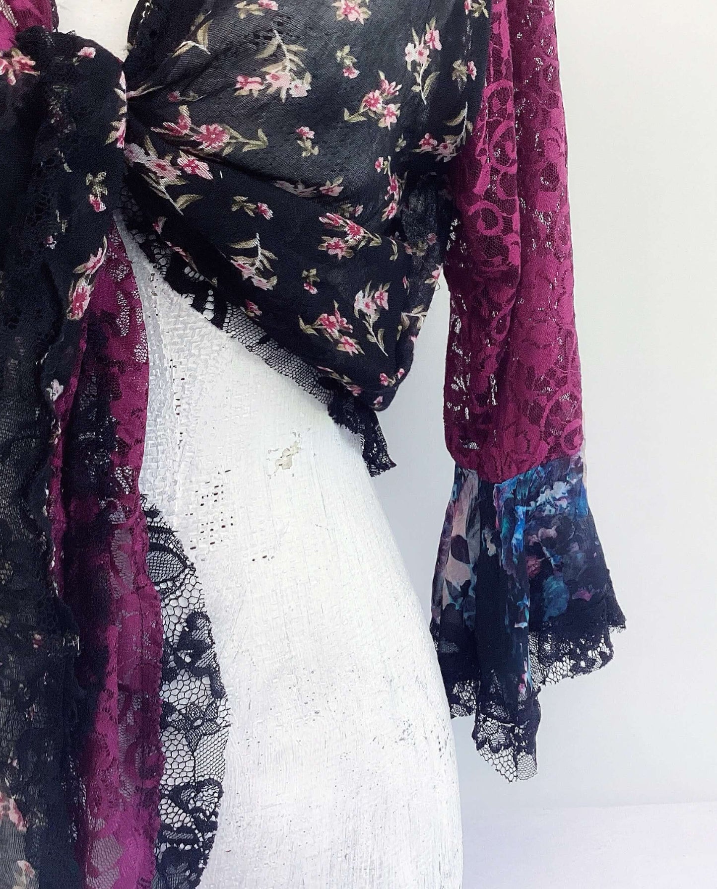 Close up view of right side floral cotton front, with plum lace sleeve, black lace on the cuff.