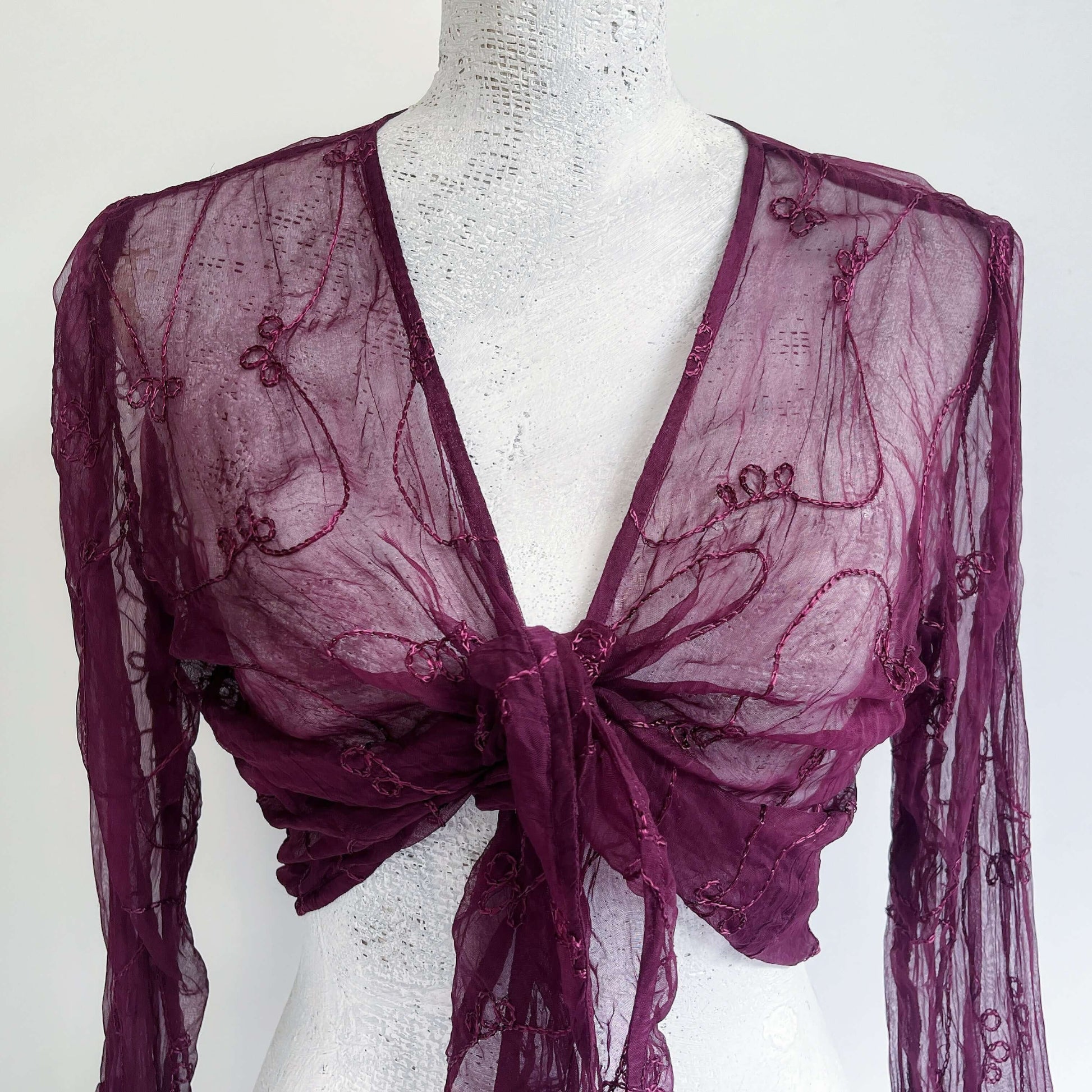 Detail view of embroidered chiffon tie top, knotted in the center.