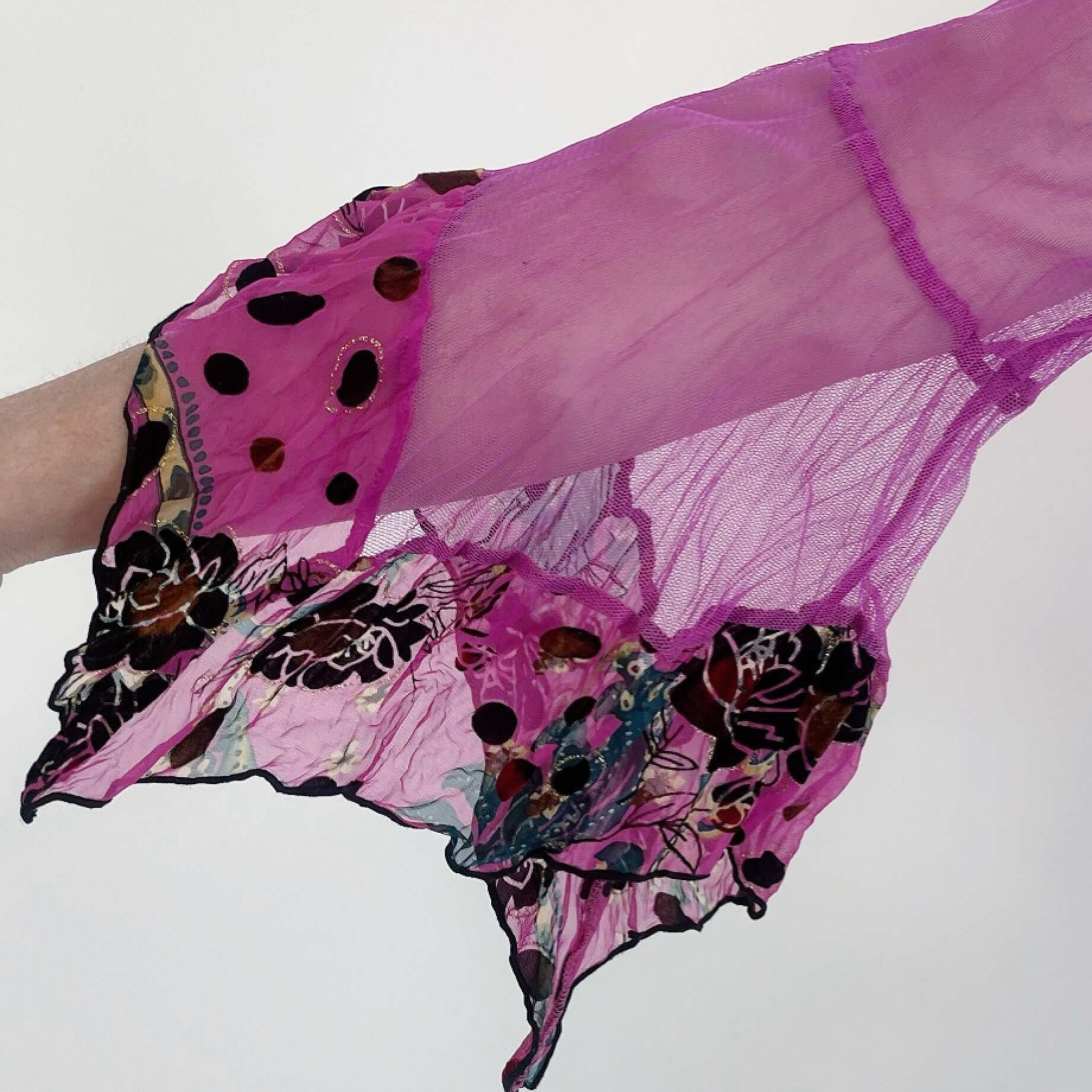 Detail view of fuchsia net sleeve, with pink printed flocked chiffon on sleeve frills.