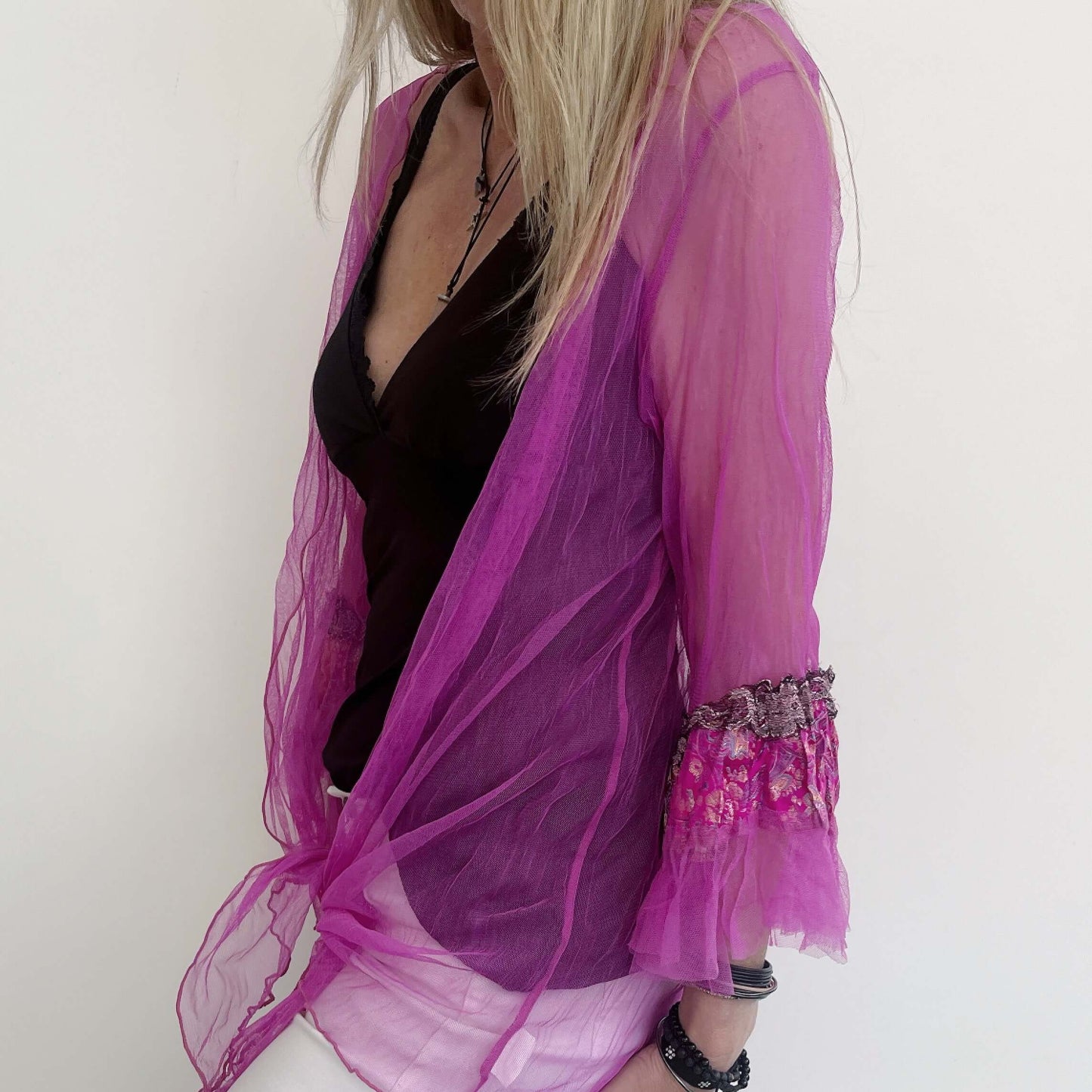 Side view of fuchsia jacket worn softly tied at the front.