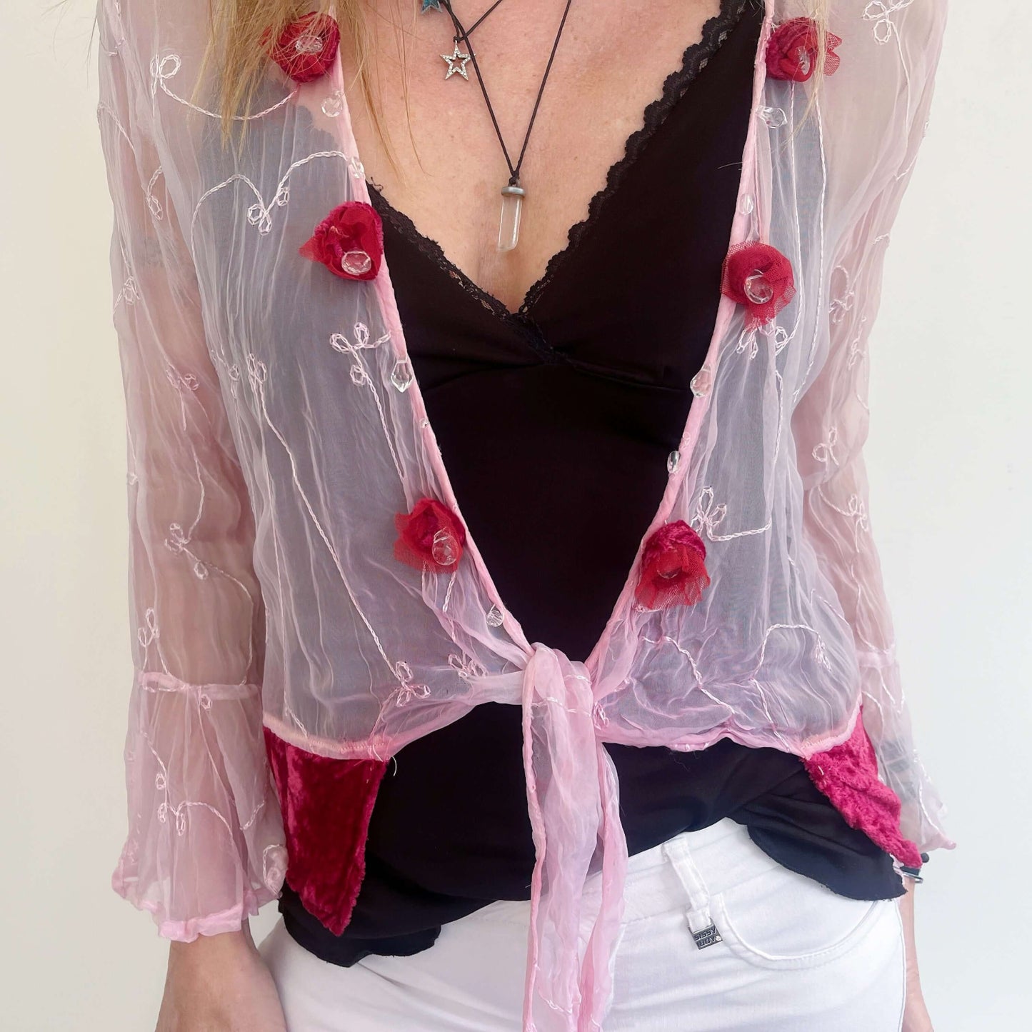 Front view tie top with cerise velvet trim on hem, and matching velvet roses and beadwork along opening, tied loosely.