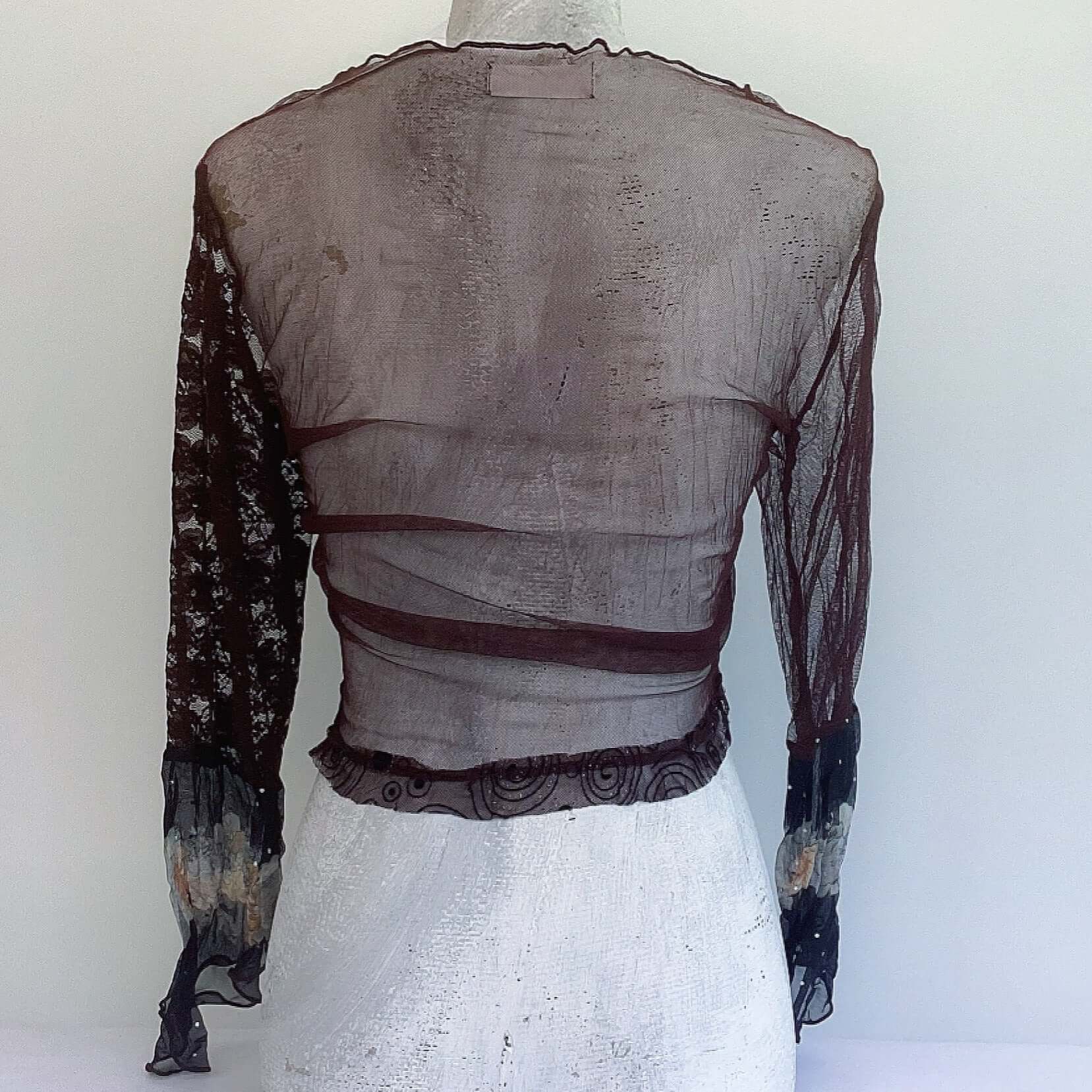 Back view of brown net on the back of the garment, black printed trim along the bottom.