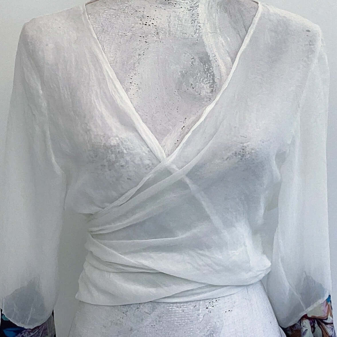 Front view of off white chiffon tie top, crossed over, tied at the back.