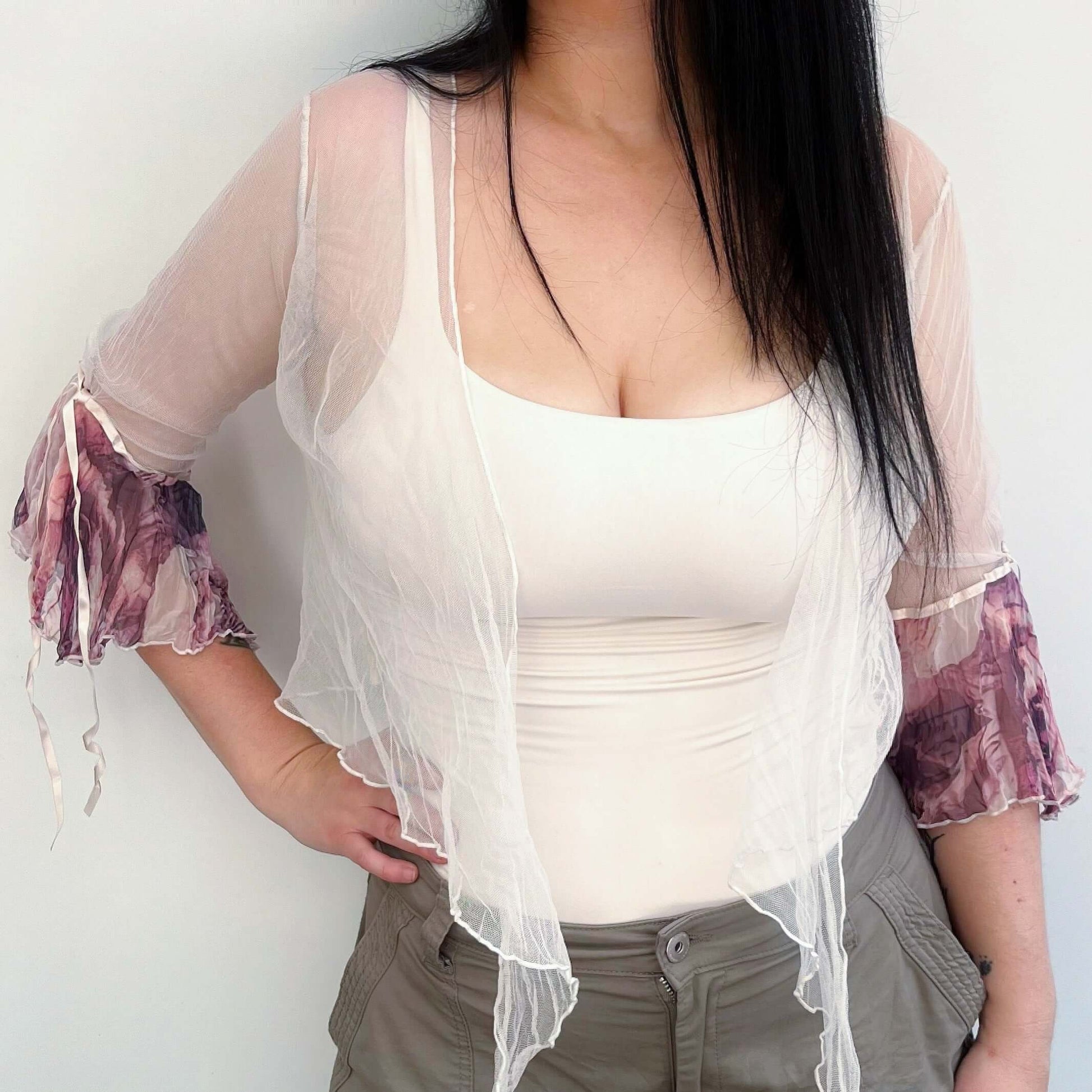 Front view of cream net tie top, with watercolor earthy toned printed chiffon sleeve frill, worn loose.