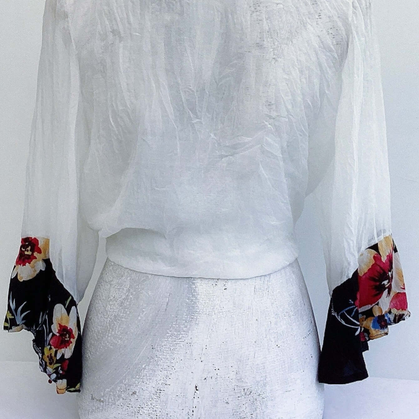 Back view of off white chiffon tie top, with red and black floral viscose cuffs.