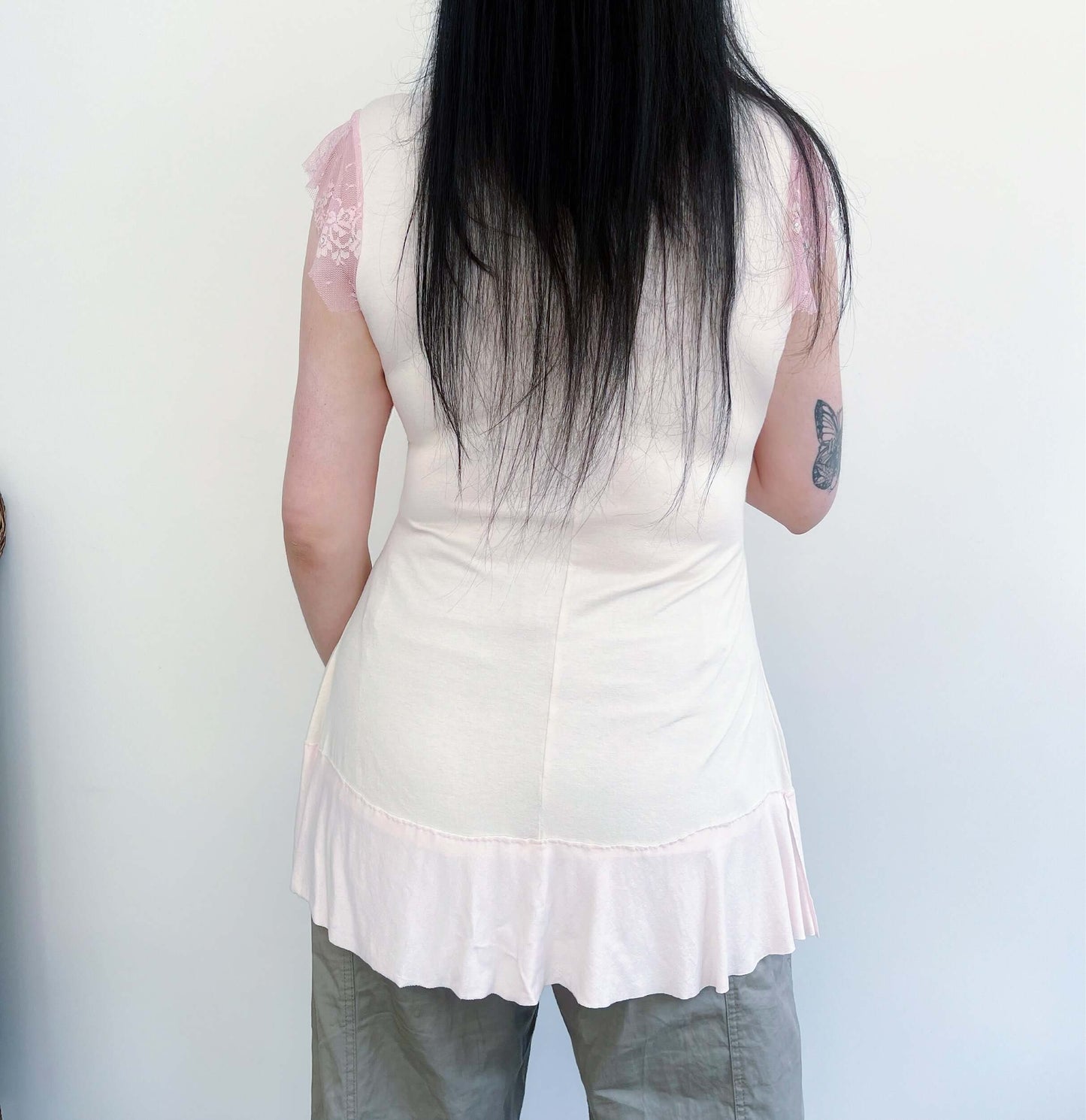 Back view of swing top, flaring out over the hip, with tiny capped lace sleeve.