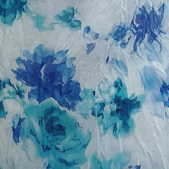 Close up view of the fabric, blue and turquoise printed flowers on pale blue background. 