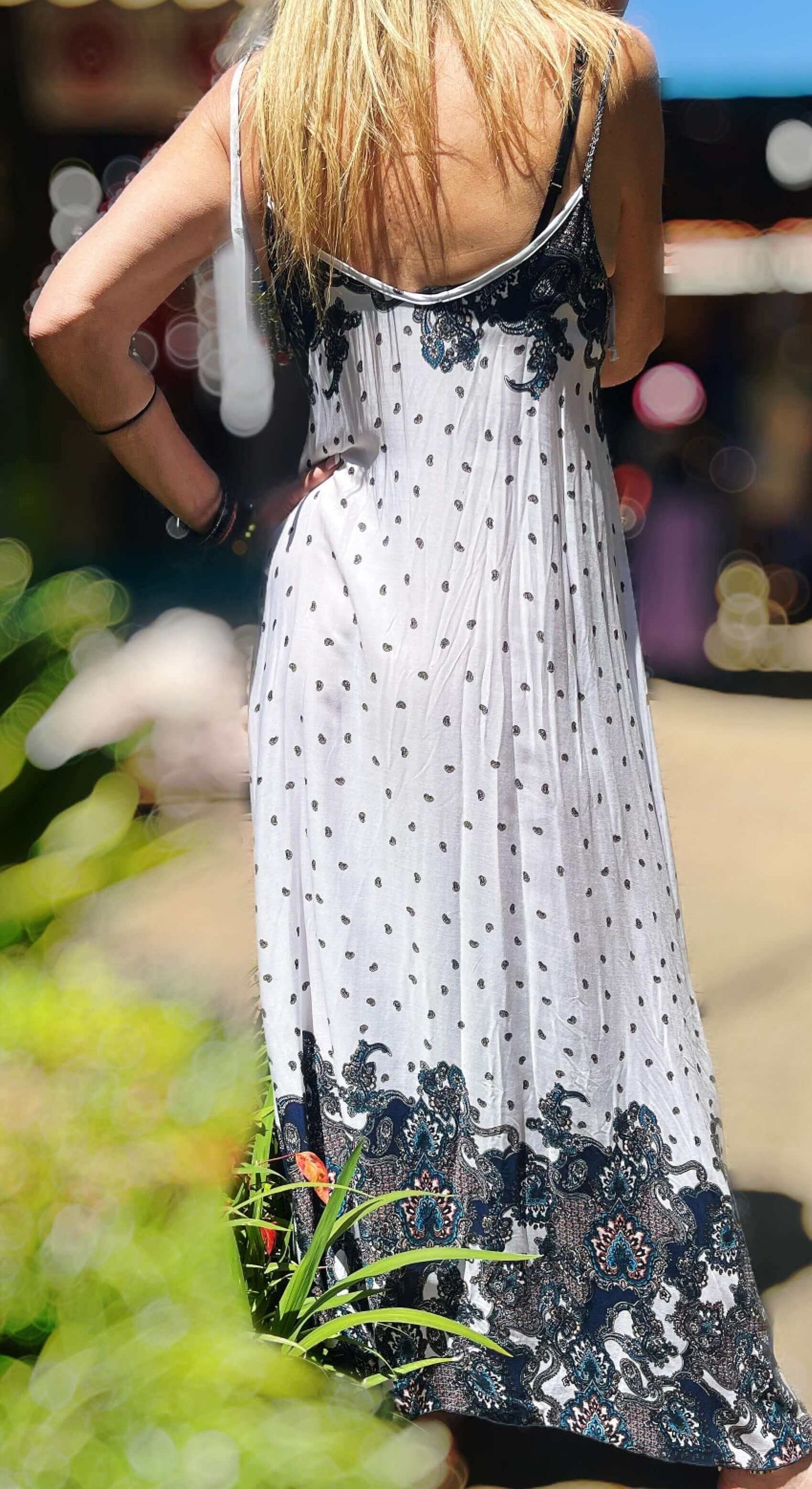 Back view of dress, basic white with small black print motif all over, with bolder indian pattern at the neck and on hem.