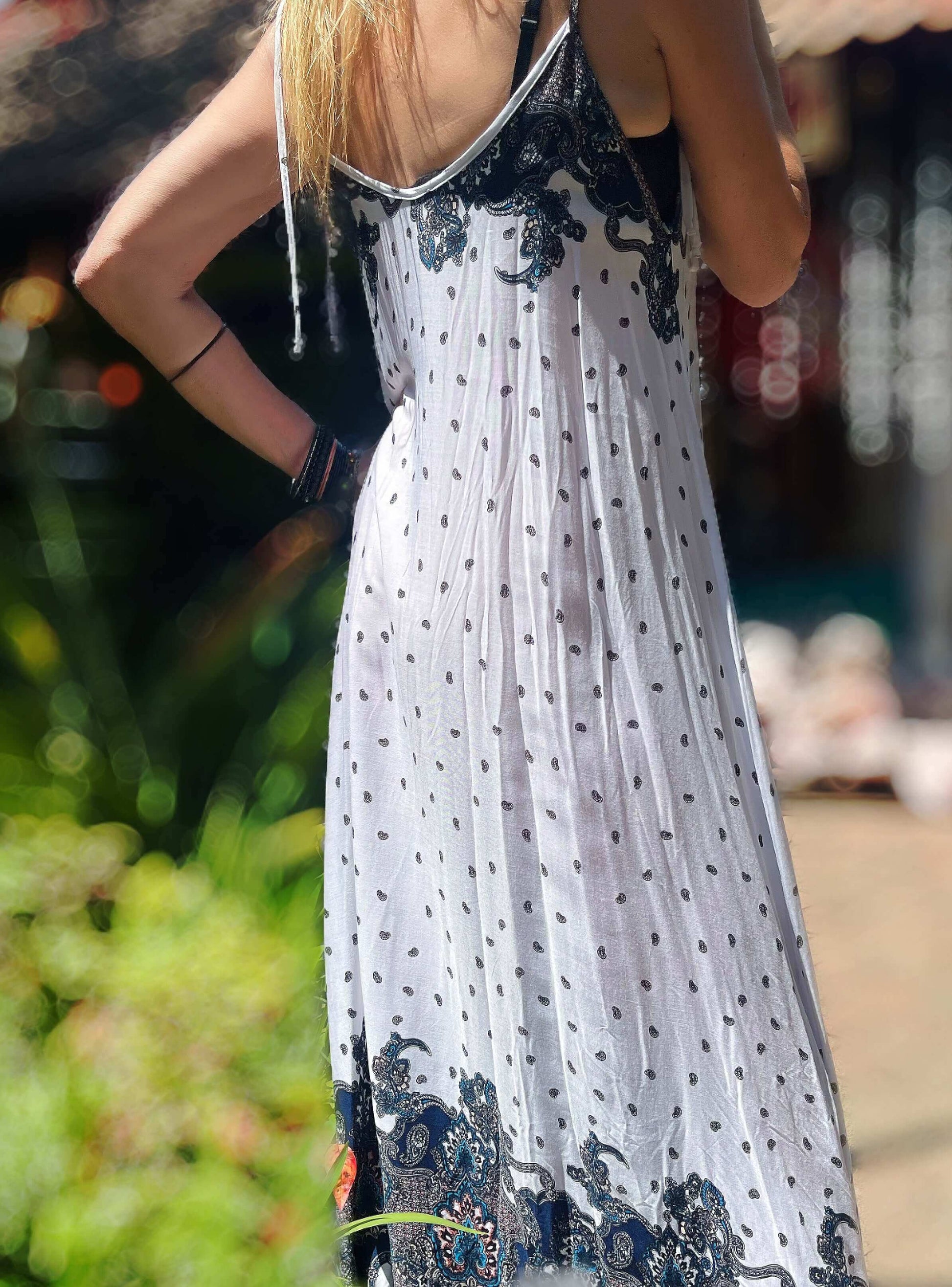 Side view of dress, basic white with small black print motif all over, with bolder indian pattern at the top of dress.