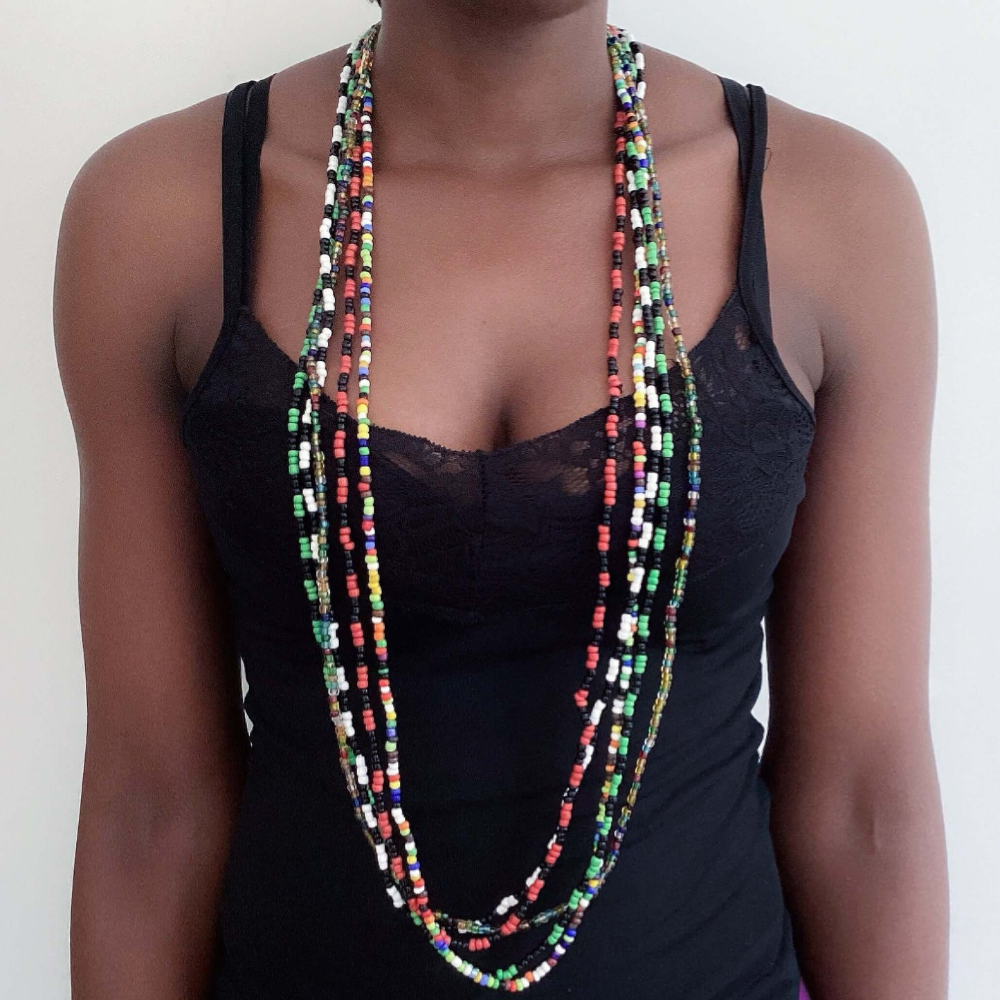 View of multiple different colored zulu beaded necklaces, all hanging together around the neck.